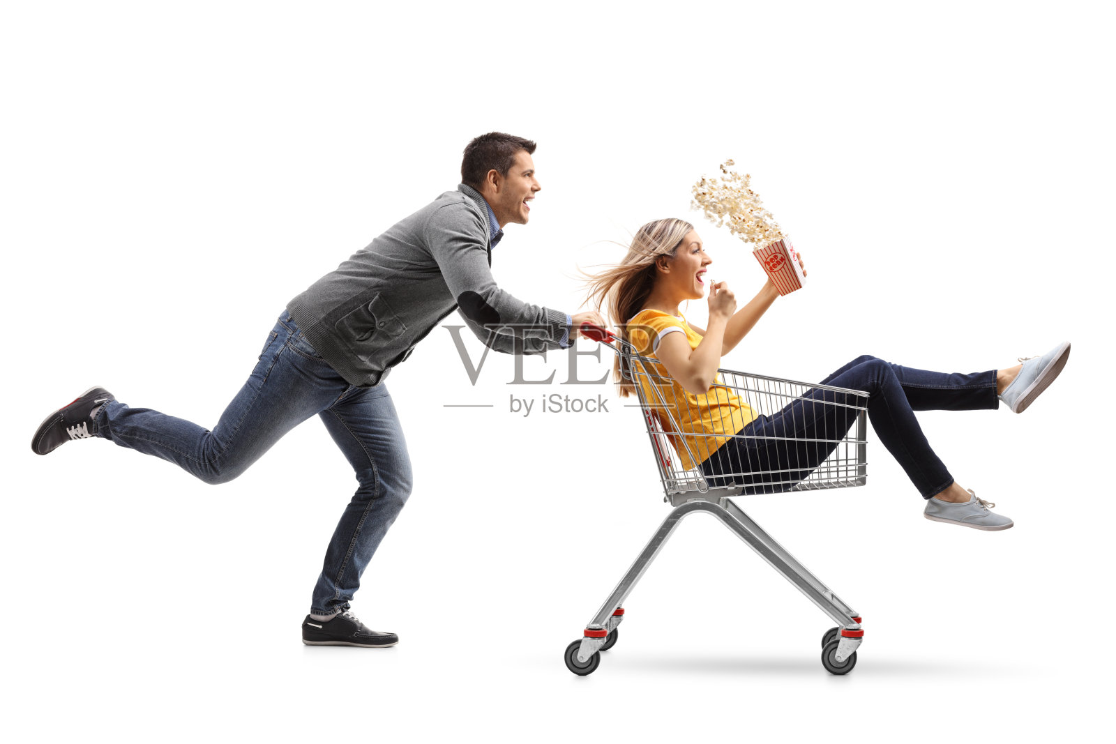 一个年轻人推着购物车，旁边是一个女人，她的车里放着爆米花照片摄影图片