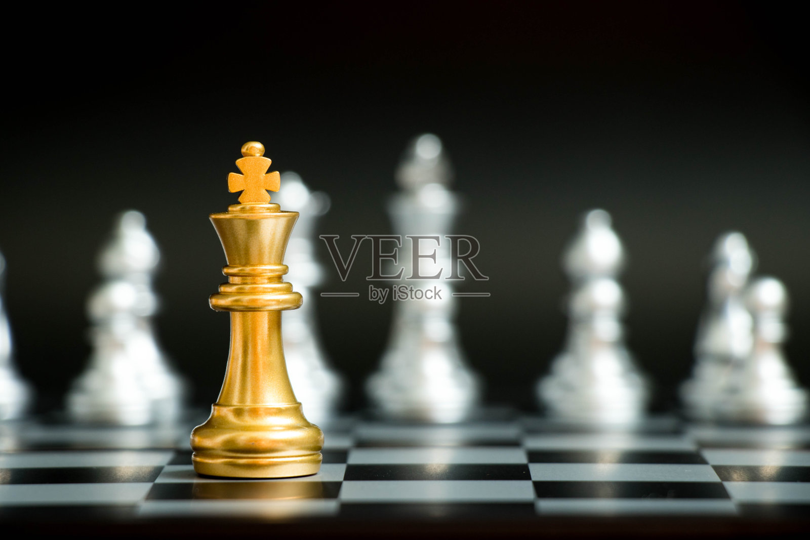 金王在棋局中面对另一支银队在黑色背景下(公司战略，商业胜利或决策的概念)照片摄影图片
