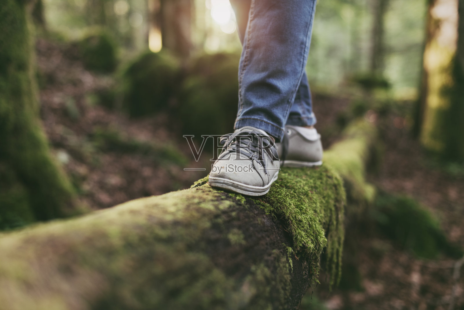 一个女人走在森林里的一根木头上照片摄影图片