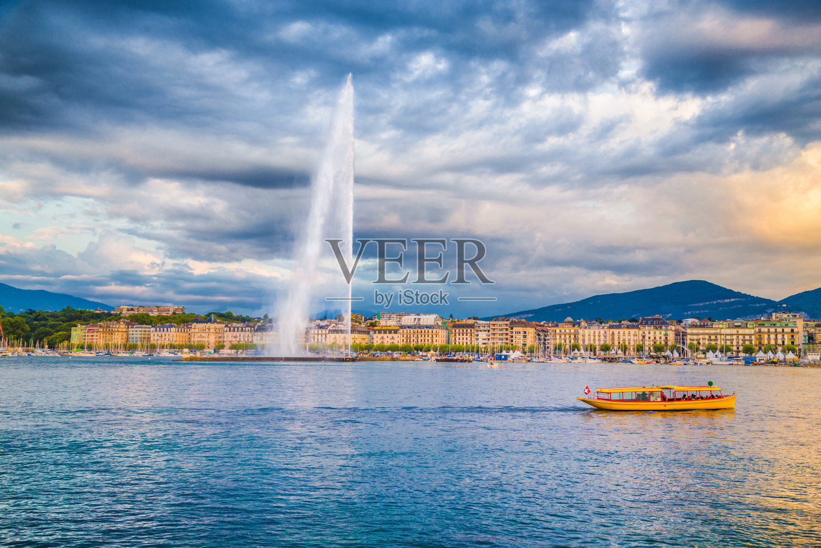 瑞士，日内瓦的天际线上有著名的喷泉和日落时的小船照片摄影图片