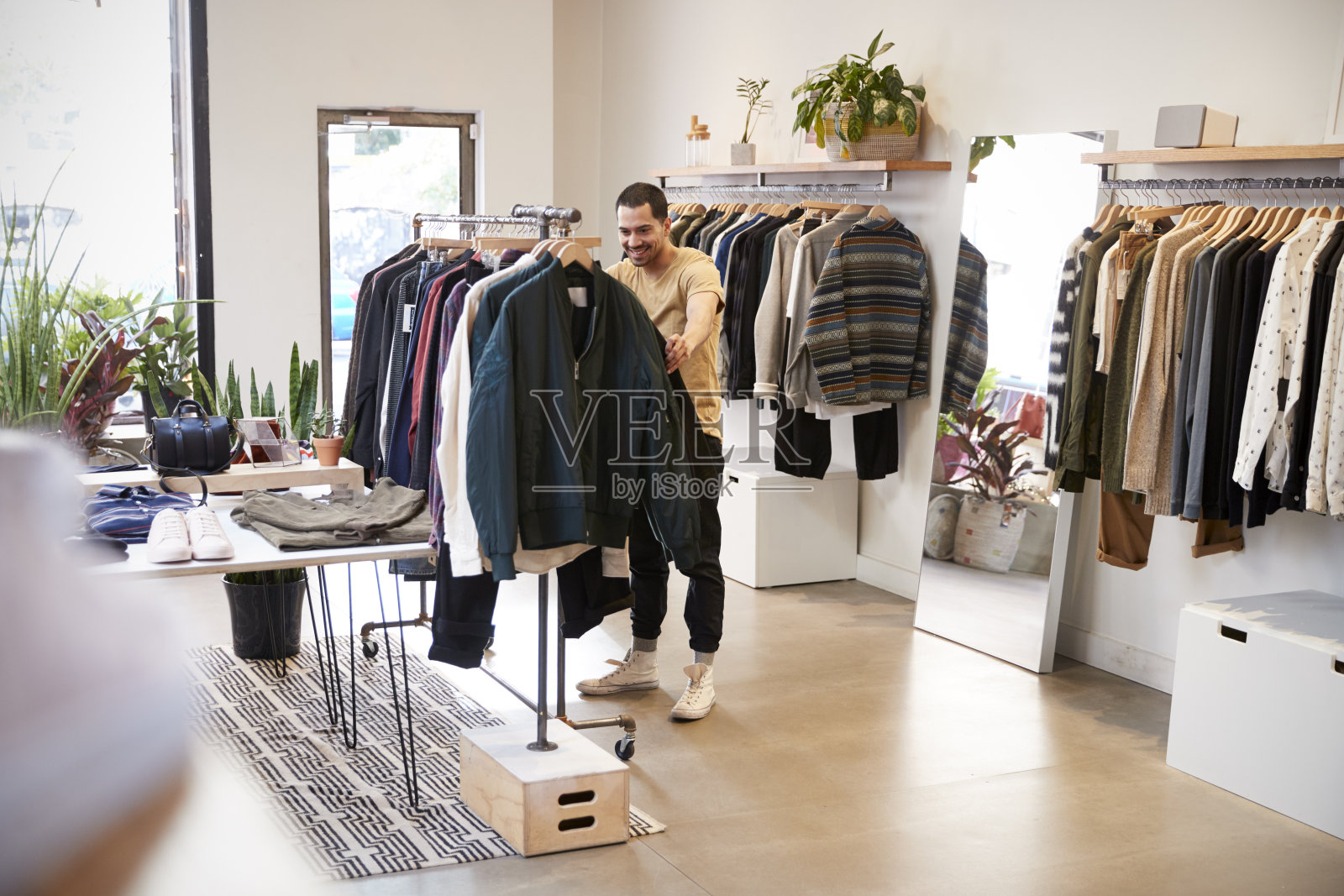 一名年轻的西班牙男子在一家商店里挑衣服照片摄影图片