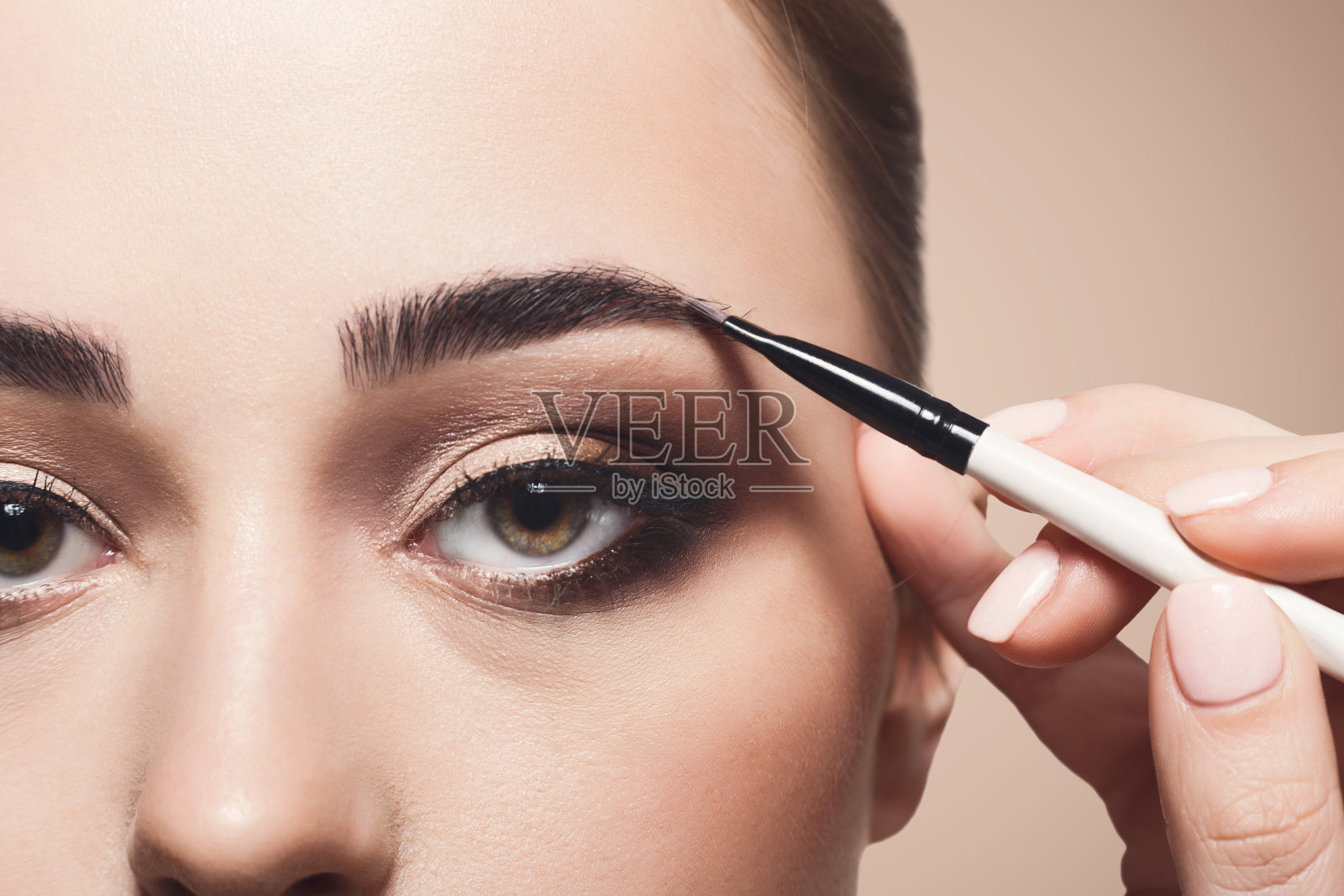 化妆师用眉刷涂抹眼影，美颜照片摄影图片