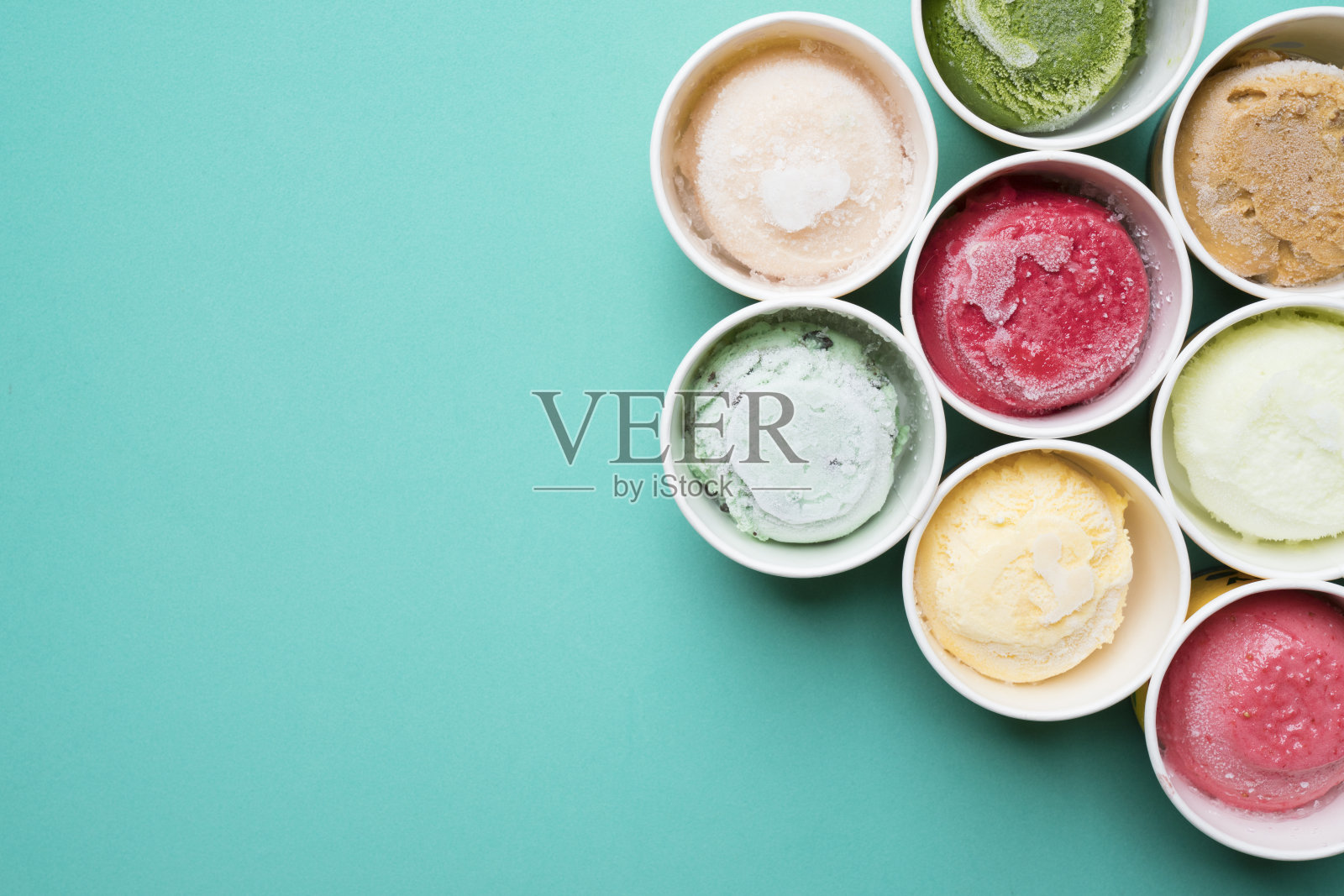 俯视图冰淇淋口味在杯子上的绿色背景照片摄影图片