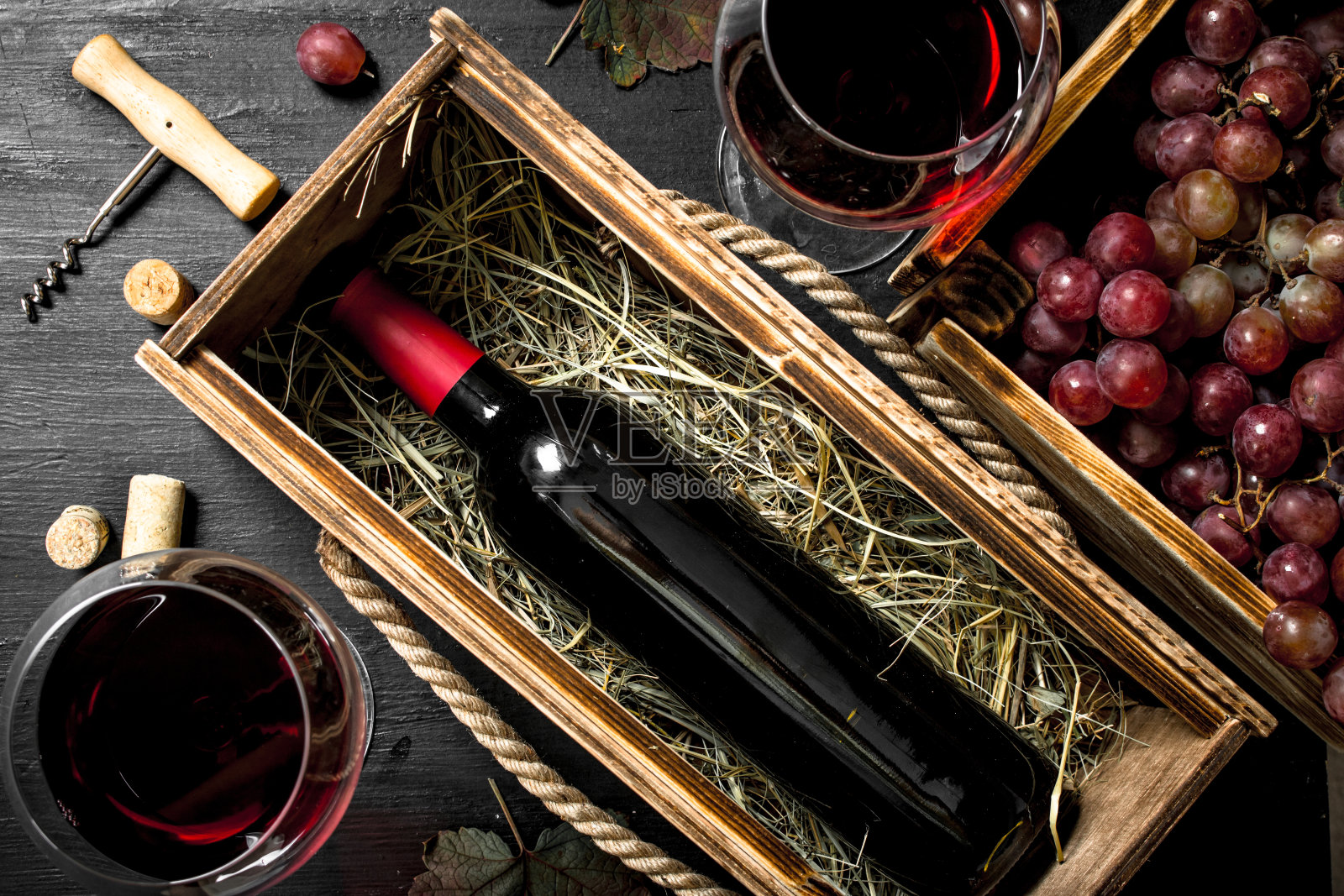葡萄酒的背景。红酒装在一个带开瓶器的旧盒子里。照片摄影图片