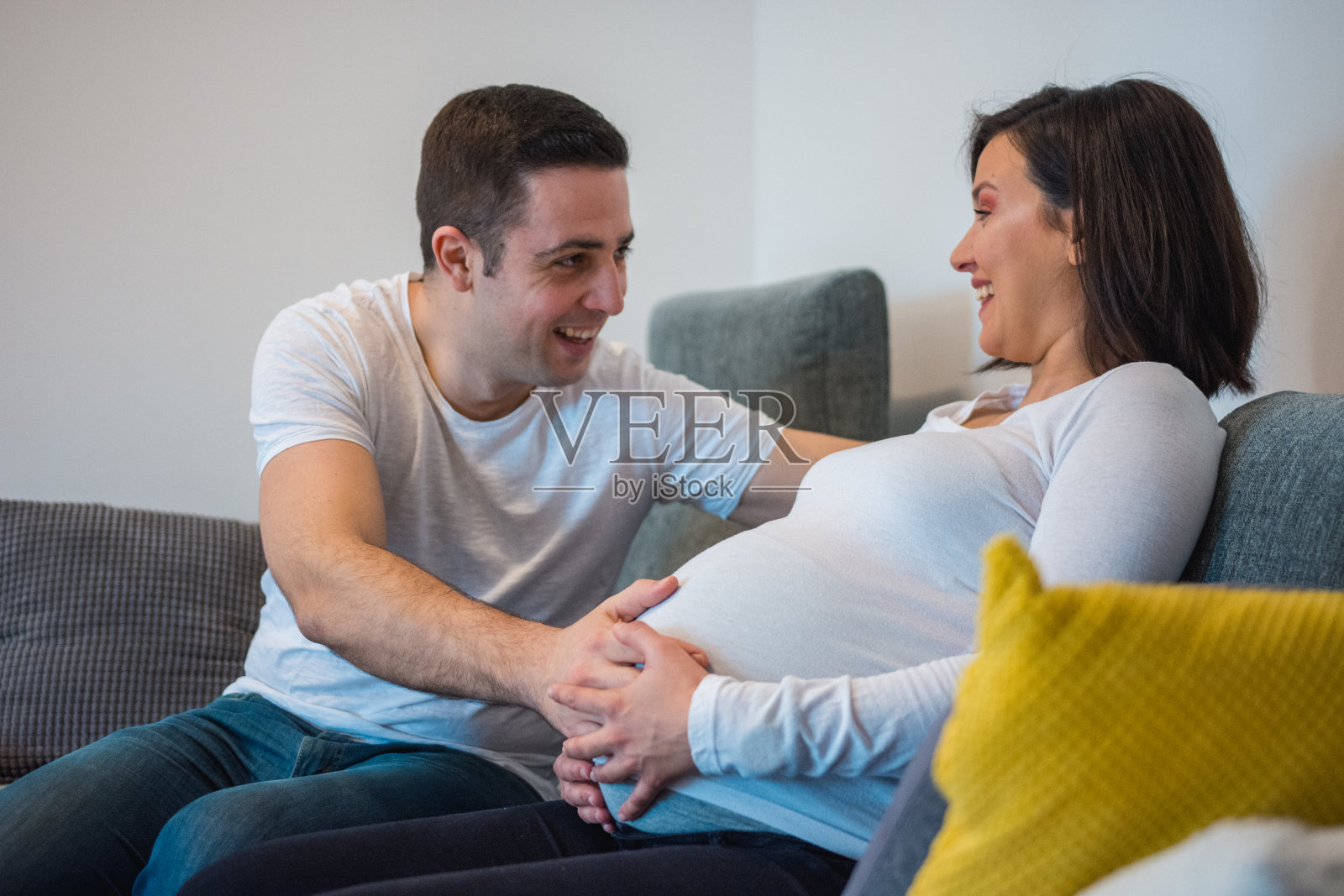 男人摸着怀孕妻子的肚子照片摄影图片