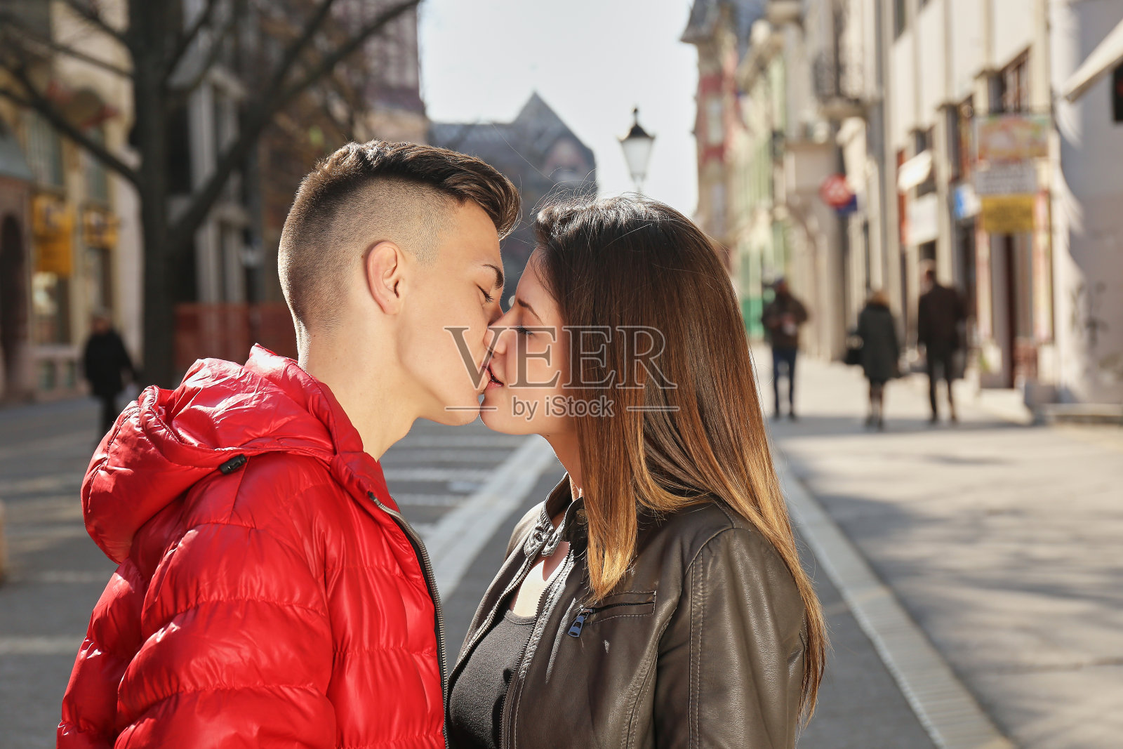 一对年轻的情侣在春天的街道上接吻照片摄影图片