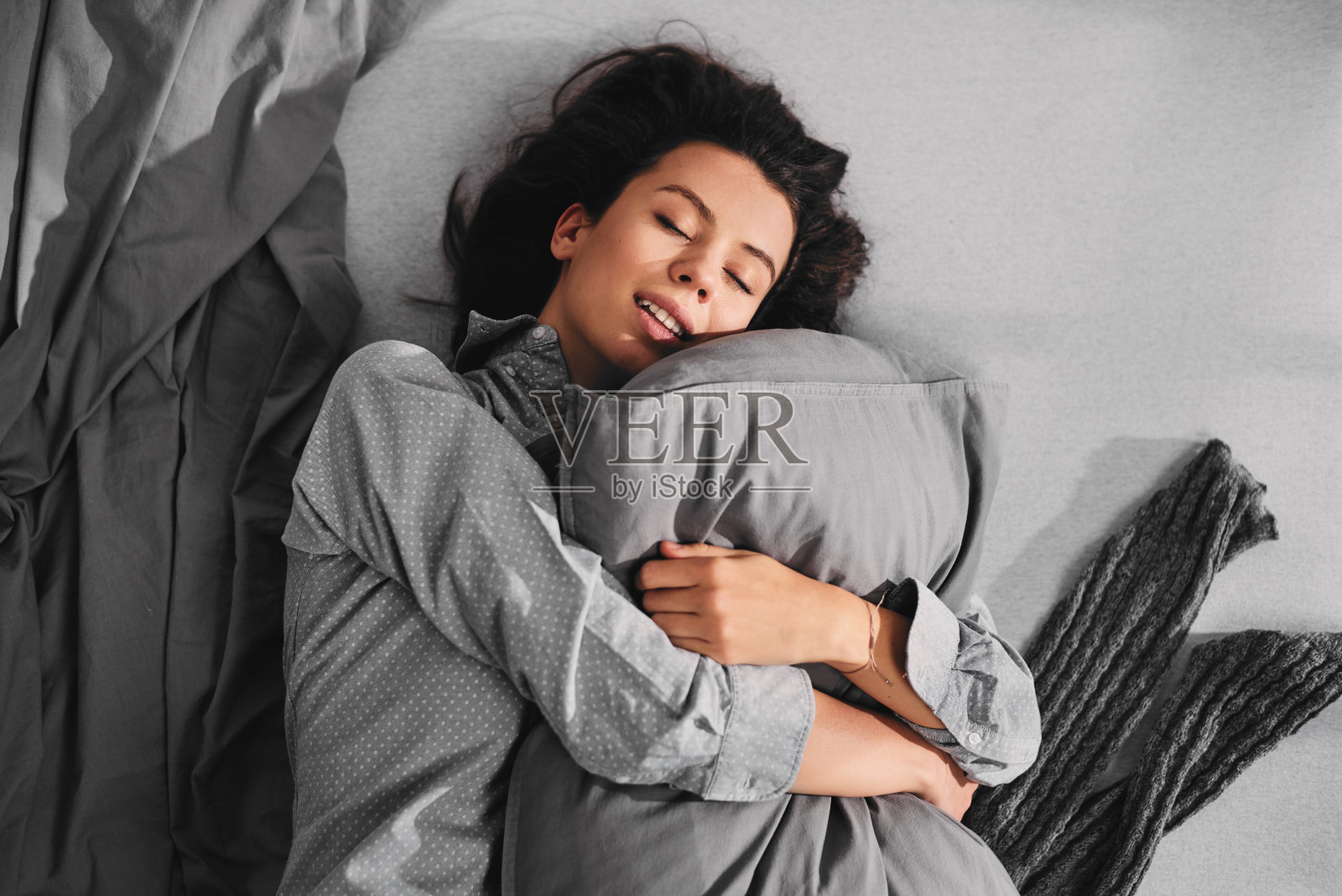睡意朦胧的女人抱着枕头的大头照照片摄影图片