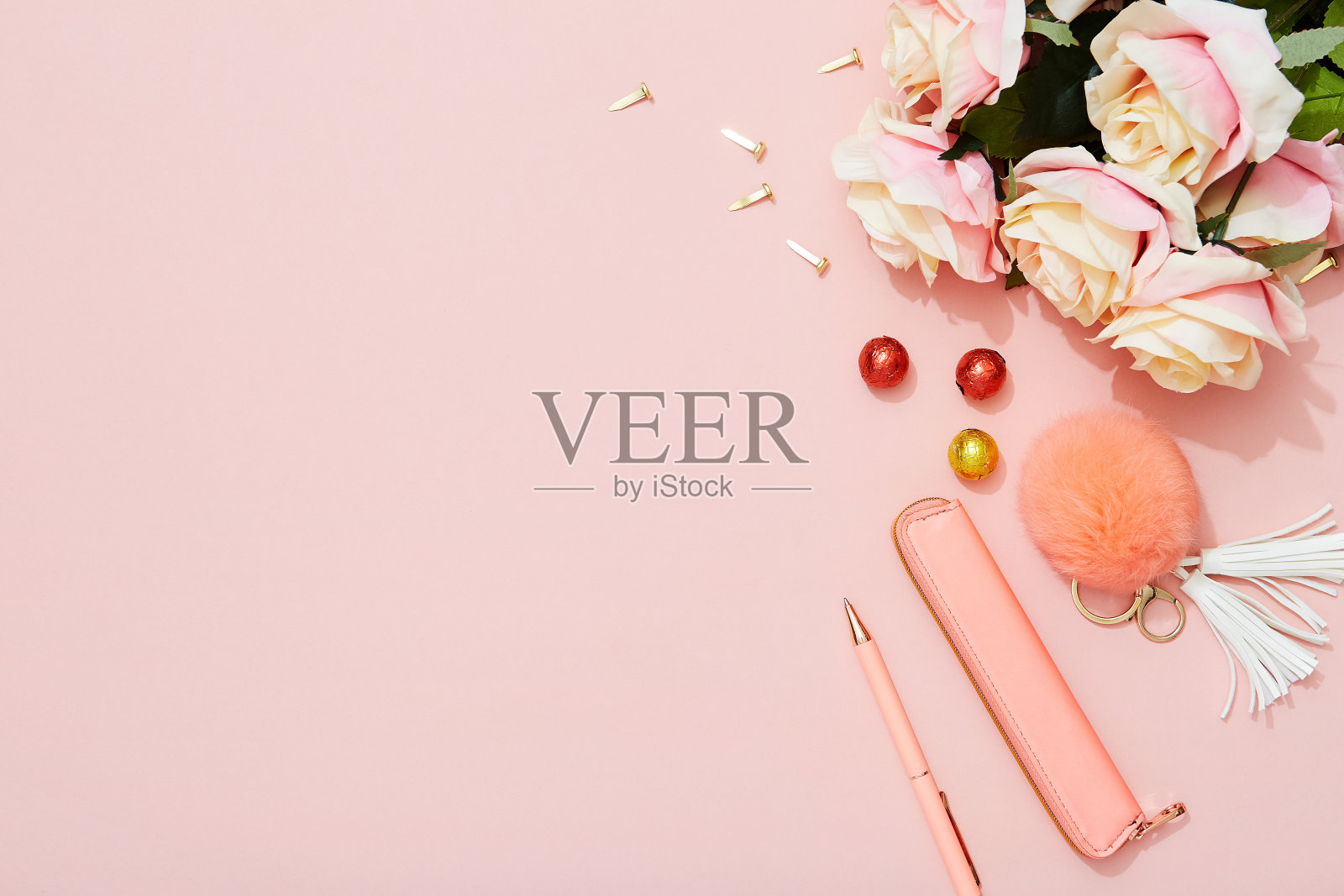女性的办公桌，粉红色背景上有玫瑰，巧克力，钢笔和时尚配件插画图片素材
