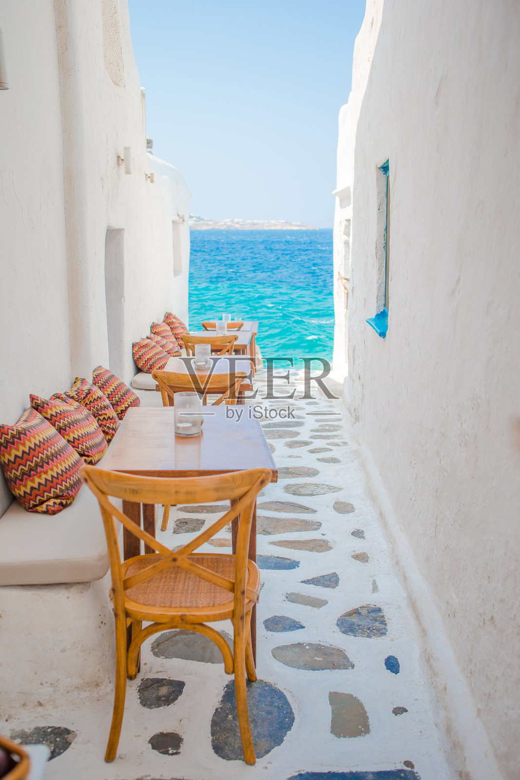 米科诺斯(Mykonos)一家典型的希腊户外咖啡馆里的枕头长椅，在基克拉迪群岛(Cyclades islands)上可以看到令人惊叹的海景照片摄影图片