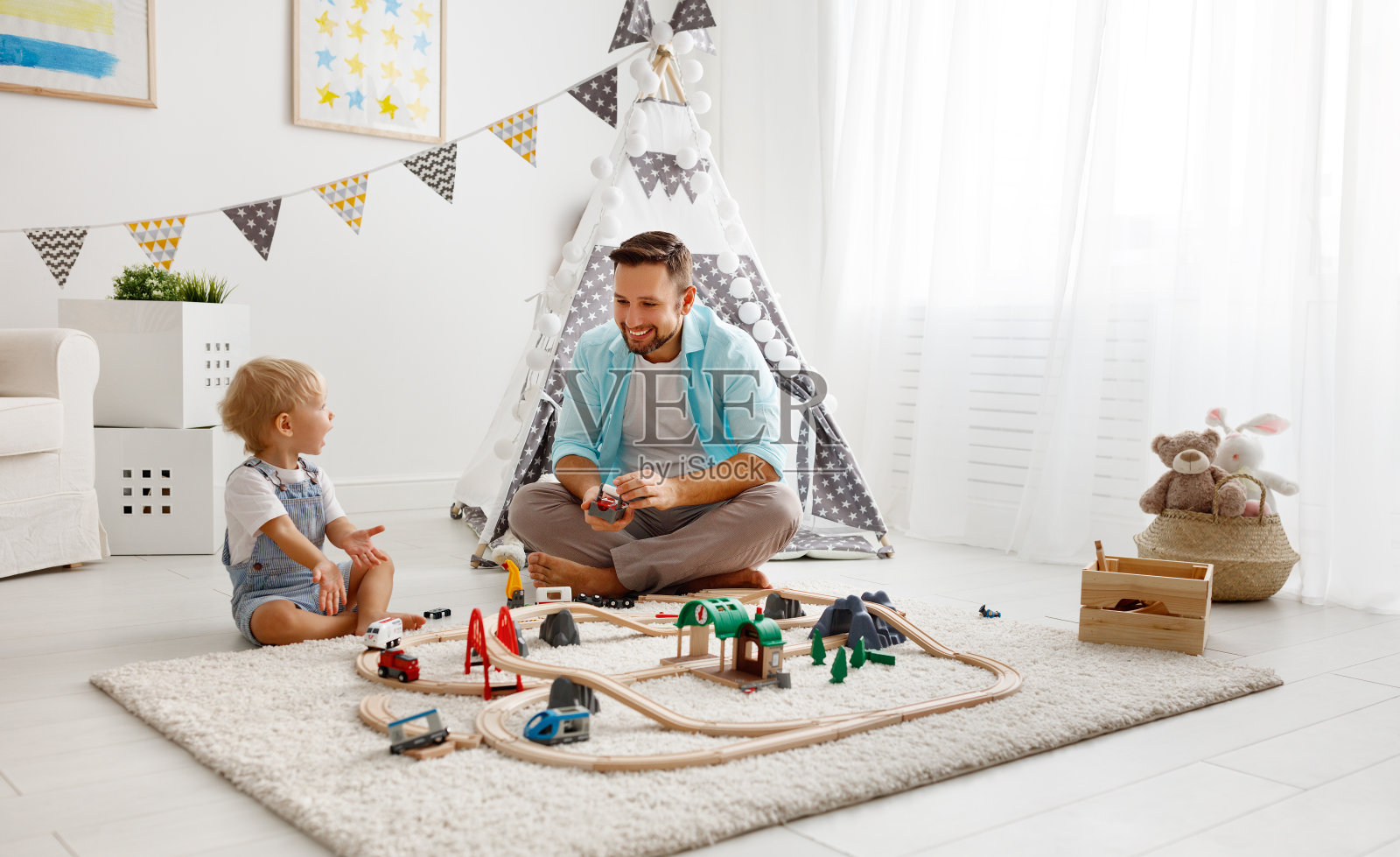 快乐的家庭，爸爸和孩子在玩具铁路玩在游戏室照片摄影图片
