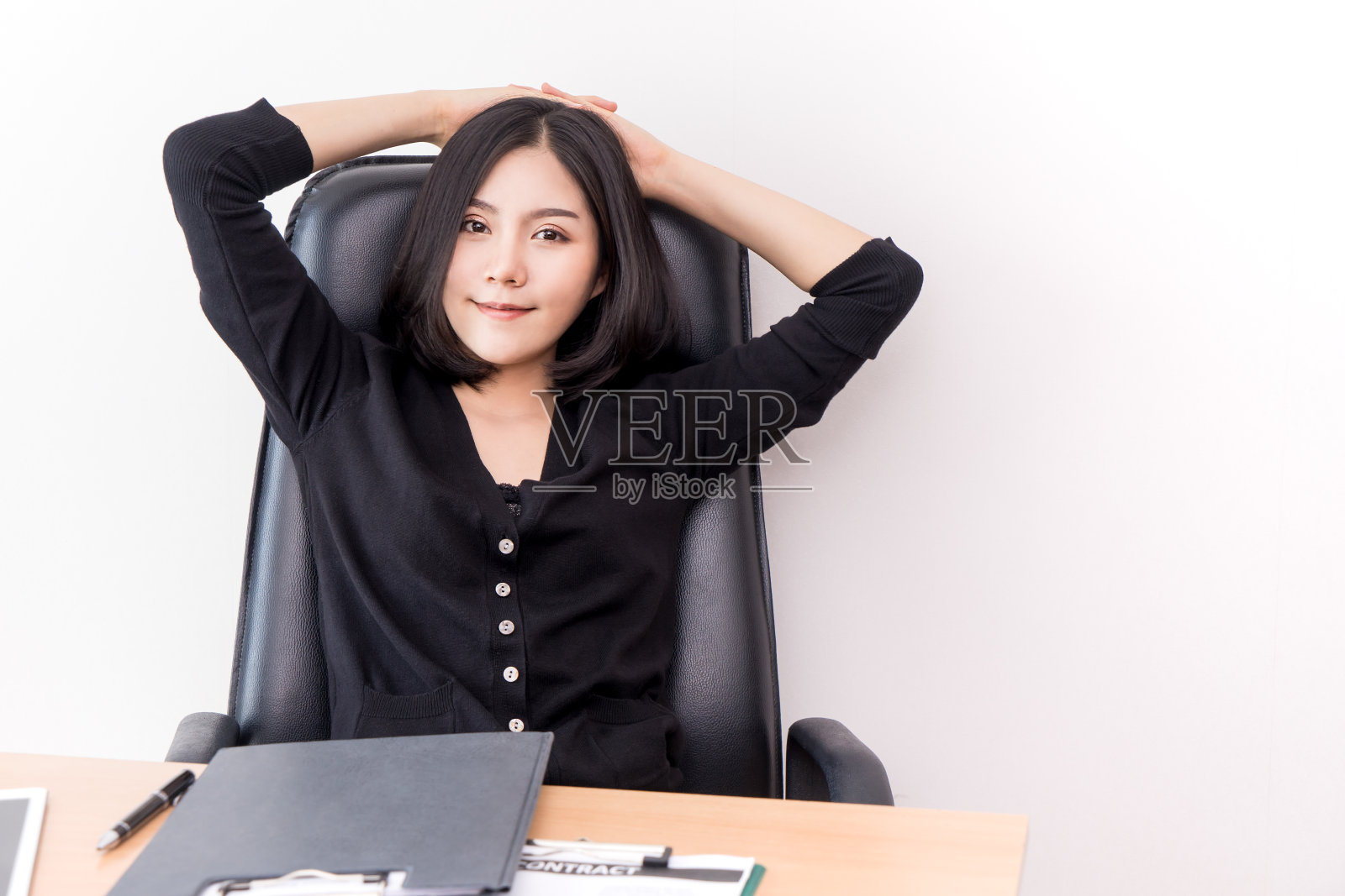 漂亮的商务女性放松地坐在办公椅上照片摄影图片