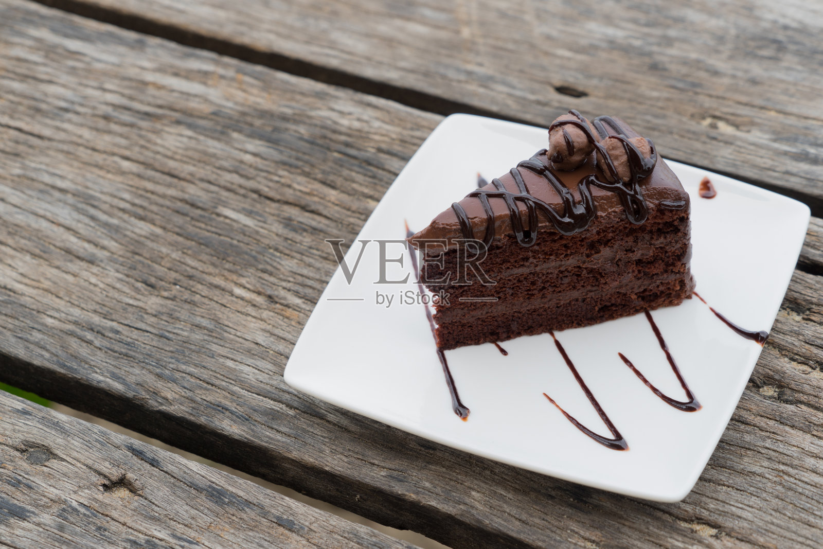 一块巧克力蛋糕的工作路径白色盘子木制桌子照片摄影图片