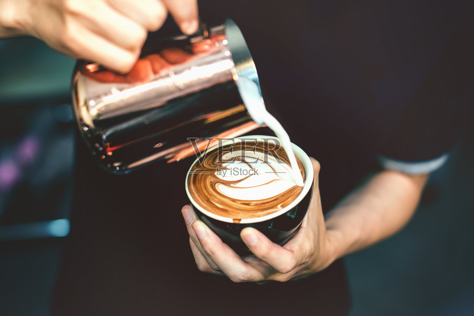 如何让咖啡师专注于牛奶和复古色调的咖啡拉花艺术。照片摄影图片