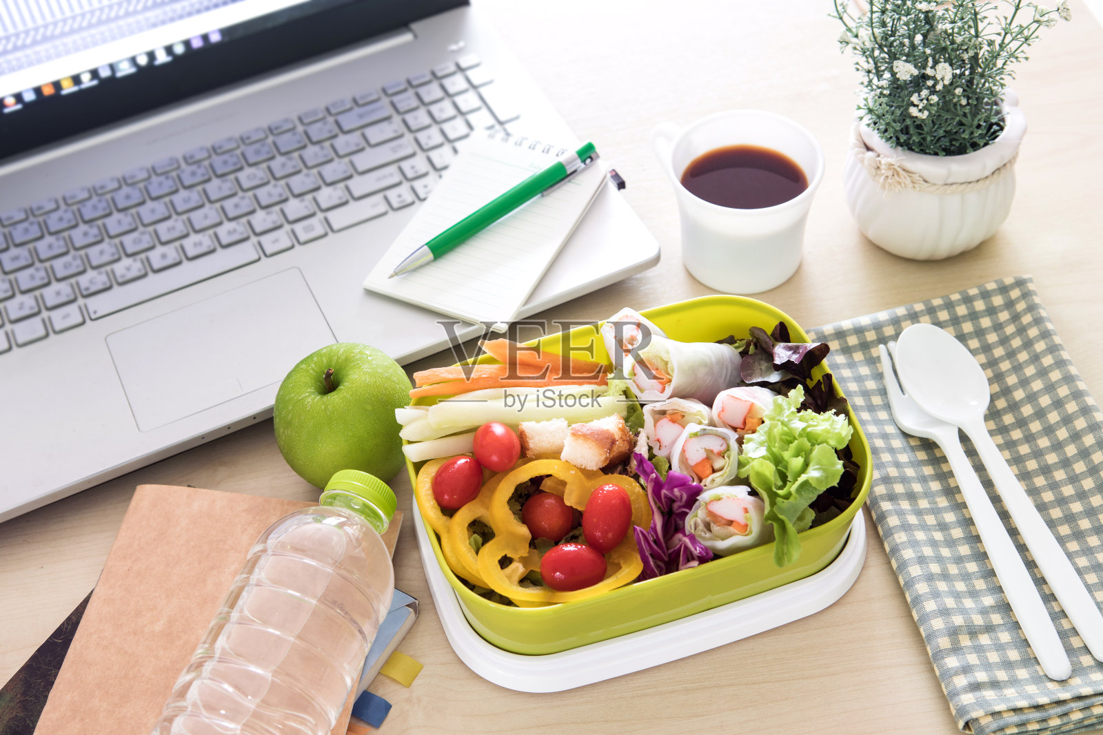 将绿色餐盒放在工作场所的办公桌上，以健康饮食、清洁饮食习惯为饮食保健理念照片摄影图片