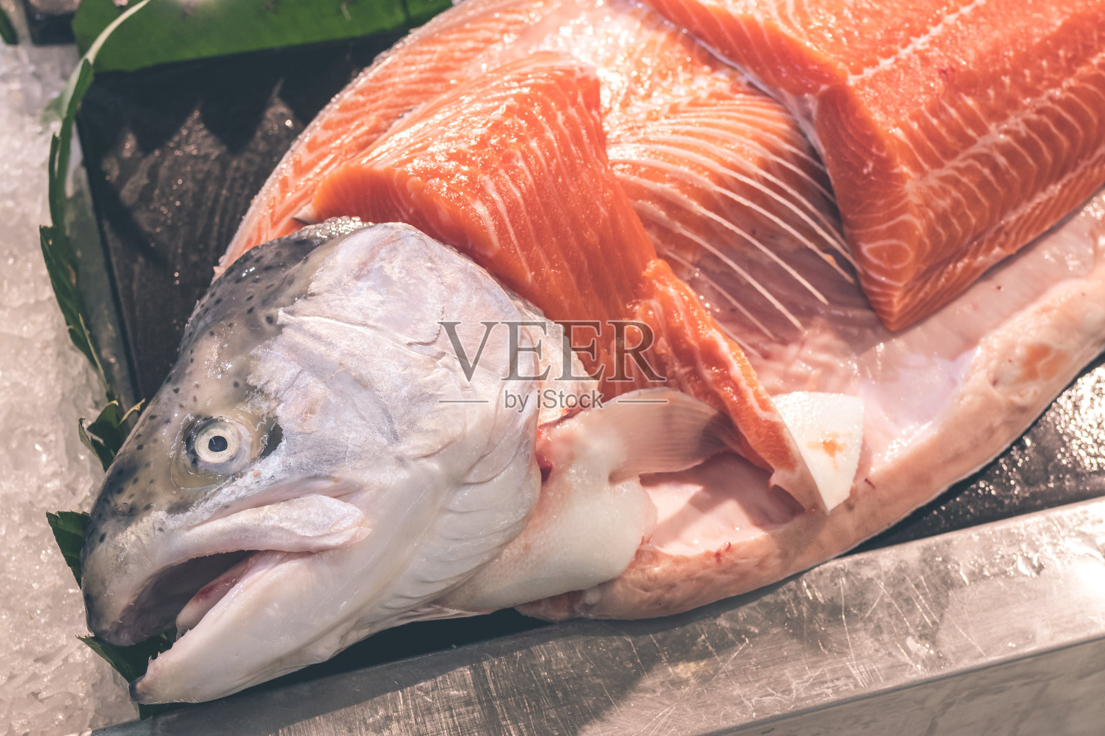 仔细观察生三文鱼片的肉质。印度尼西亚巴厘岛当地食品市场上的生鲑鱼和大西洋鱼照片摄影图片