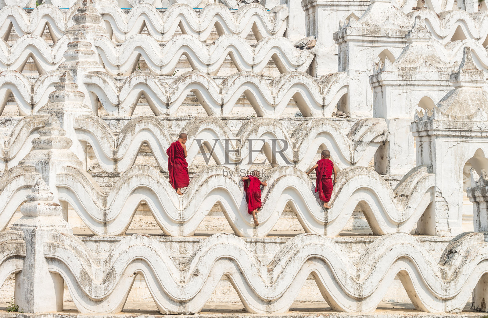 在缅甸曼德勒的蒲甘，三个年轻的和尚正爬上密登潭塔照片摄影图片