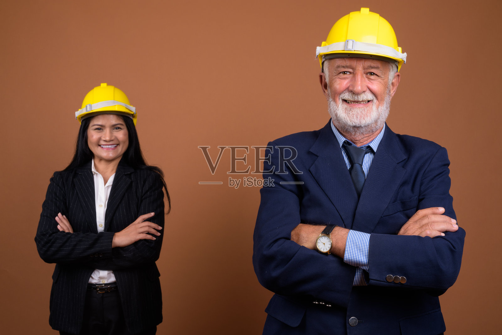 工作室拍摄的成熟的多民族商业夫妇与安全帽，以彩色背景照片摄影图片