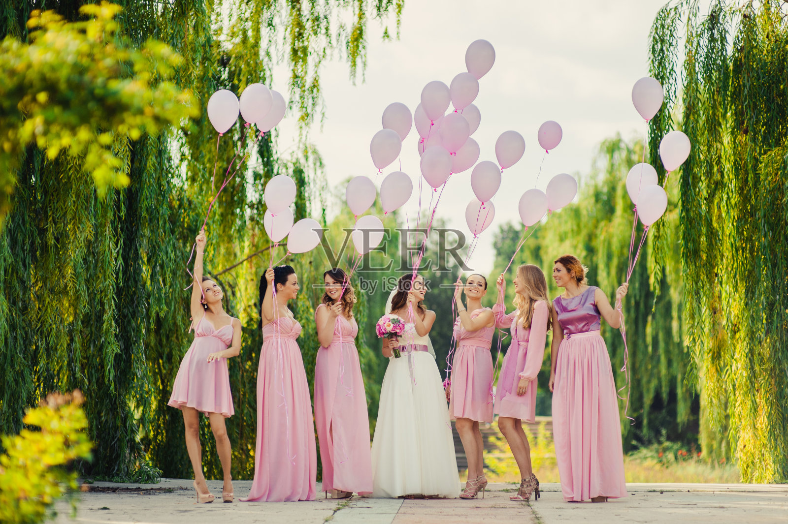新娘和穿着粉色礼服的伴娘一起散步照片摄影图片