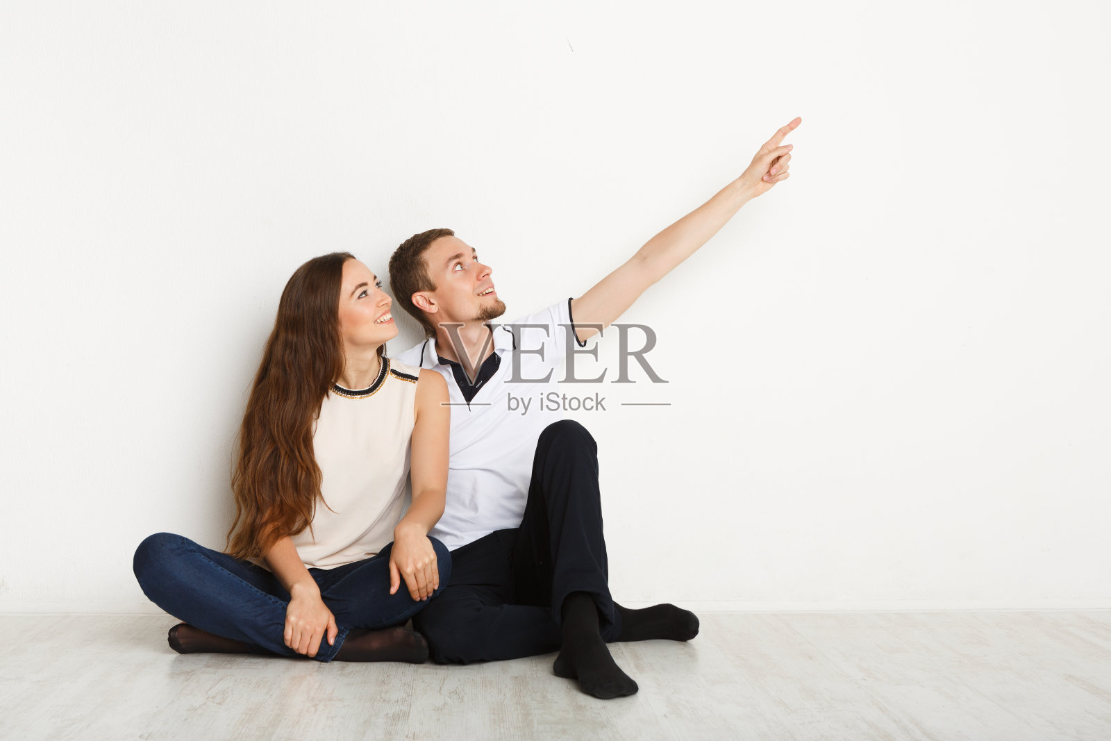 一对夫妇坐在地板上，看向别处照片摄影图片