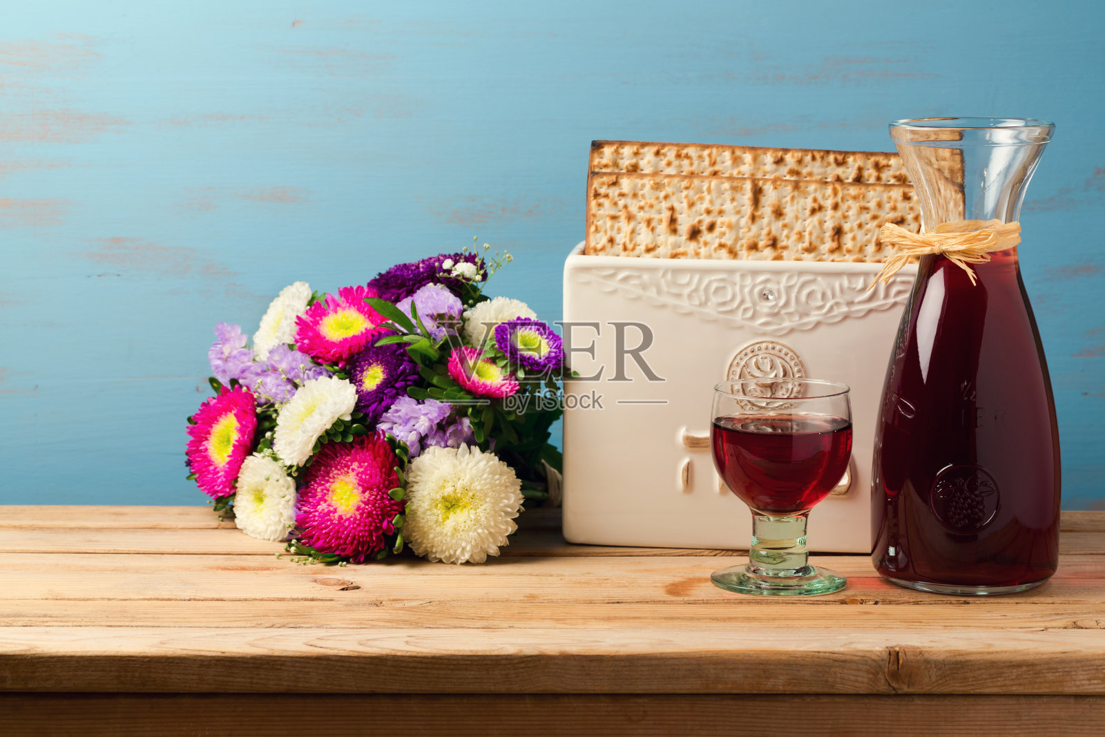 犹太节日逾越节的概念与葡萄酒，无酵饼和春天的花在木制的背景照片摄影图片