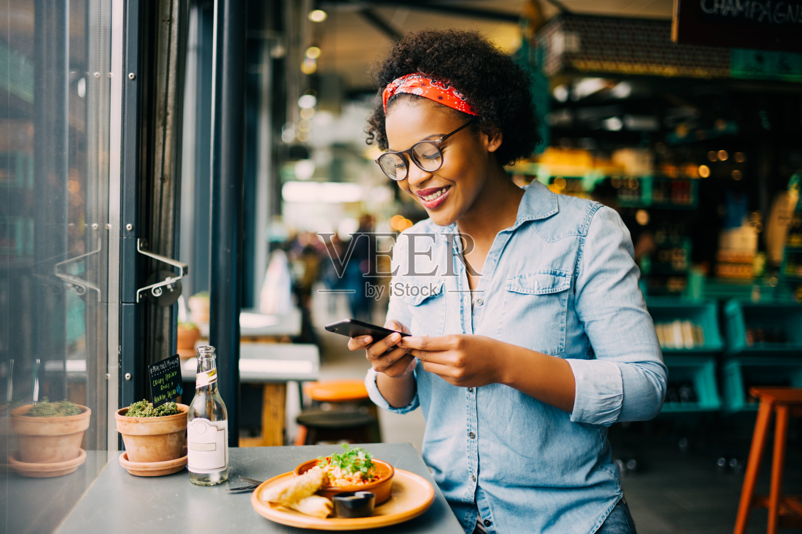 微笑的女人在拍她的食物在一个咖啡馆照片摄影图片