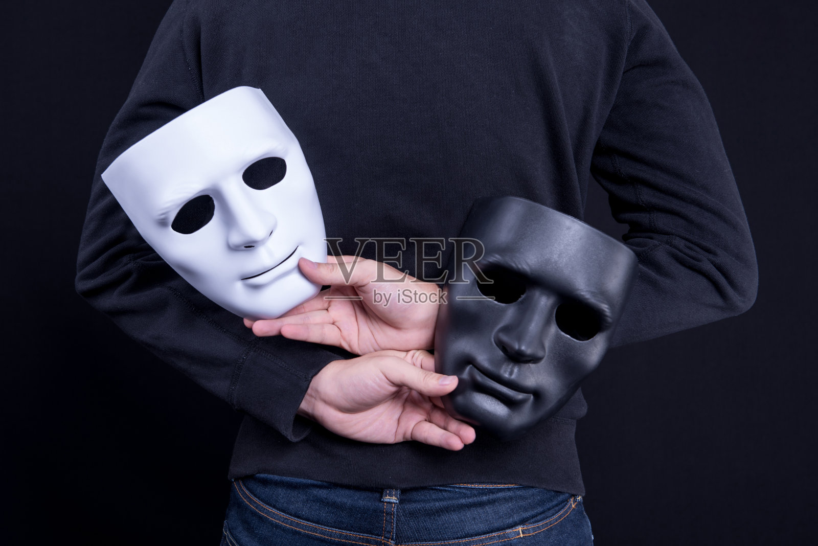 手持黑白面具的神秘男子。匿名社会掩蔽概念。照片摄影图片