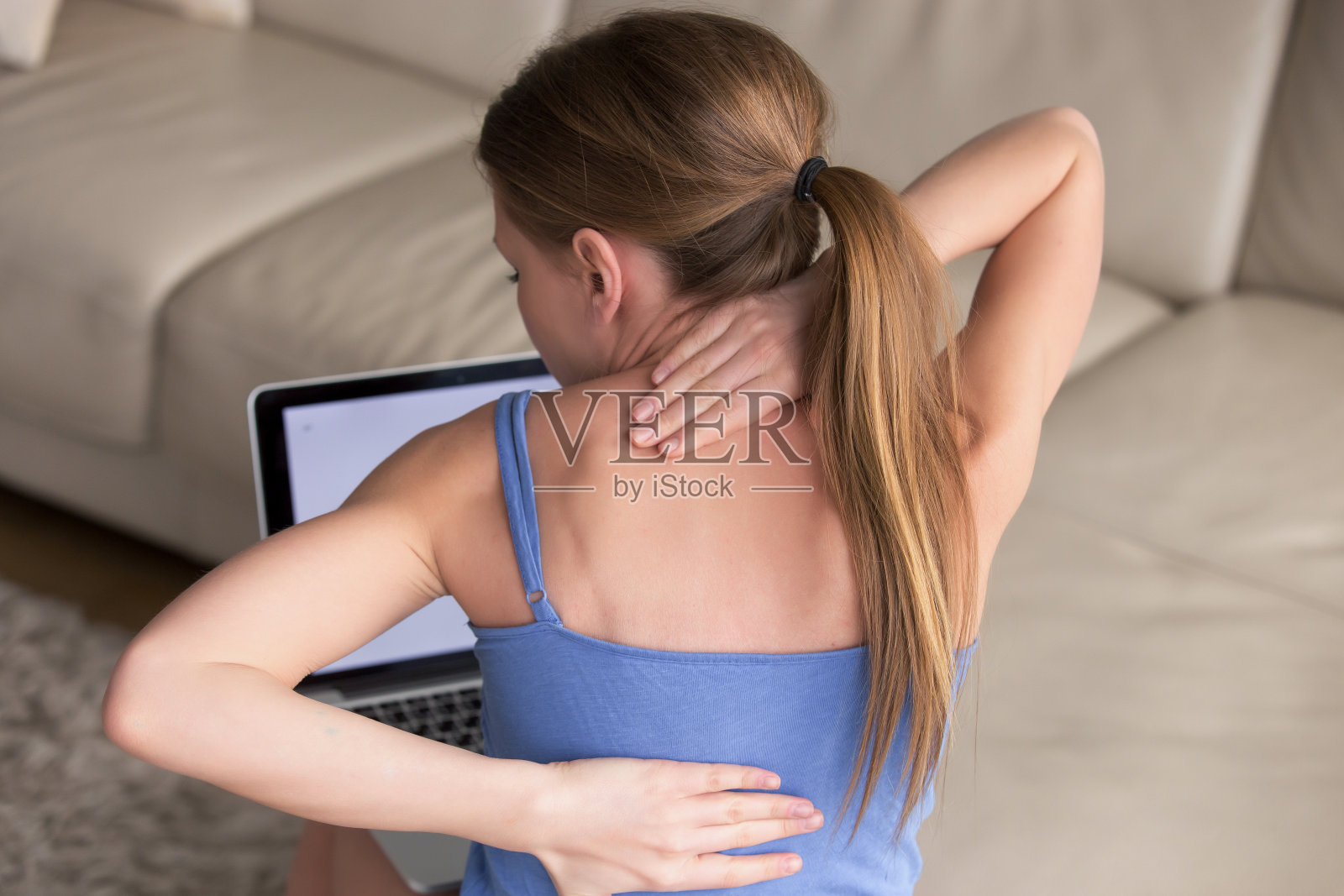 女人按摩她紧张而僵硬的背部肌肉照片摄影图片