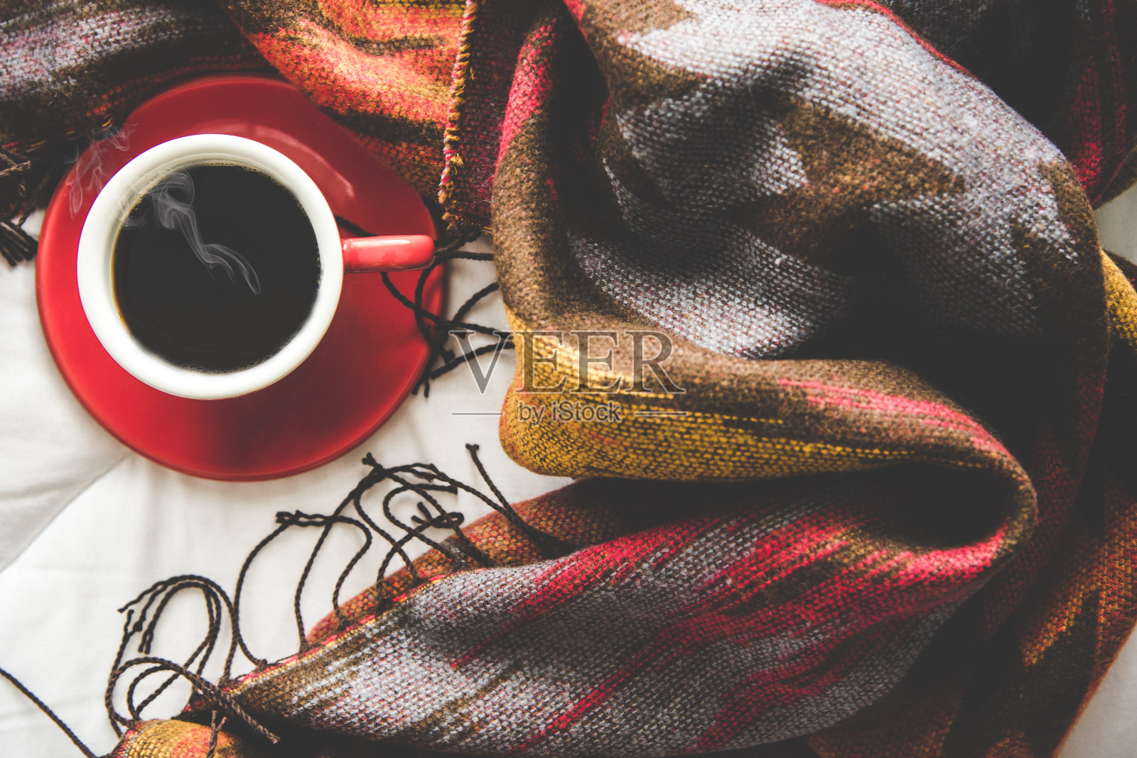 舒适的冬天家背景，一杯热咖啡与棉花糖，温暖的针织毛衣在白色的床背景，复古的色调。生活方式的概念照片摄影图片