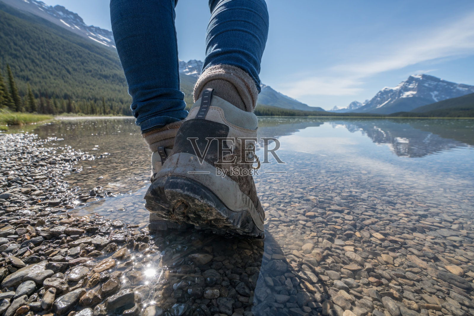 徒步旅行者到达山上的湖，靴子靠近照片摄影图片