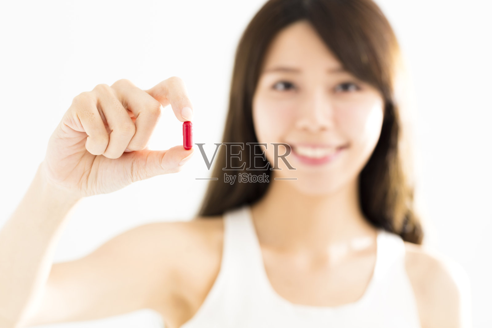 微笑的年轻女子展示在手里的药丸照片摄影图片