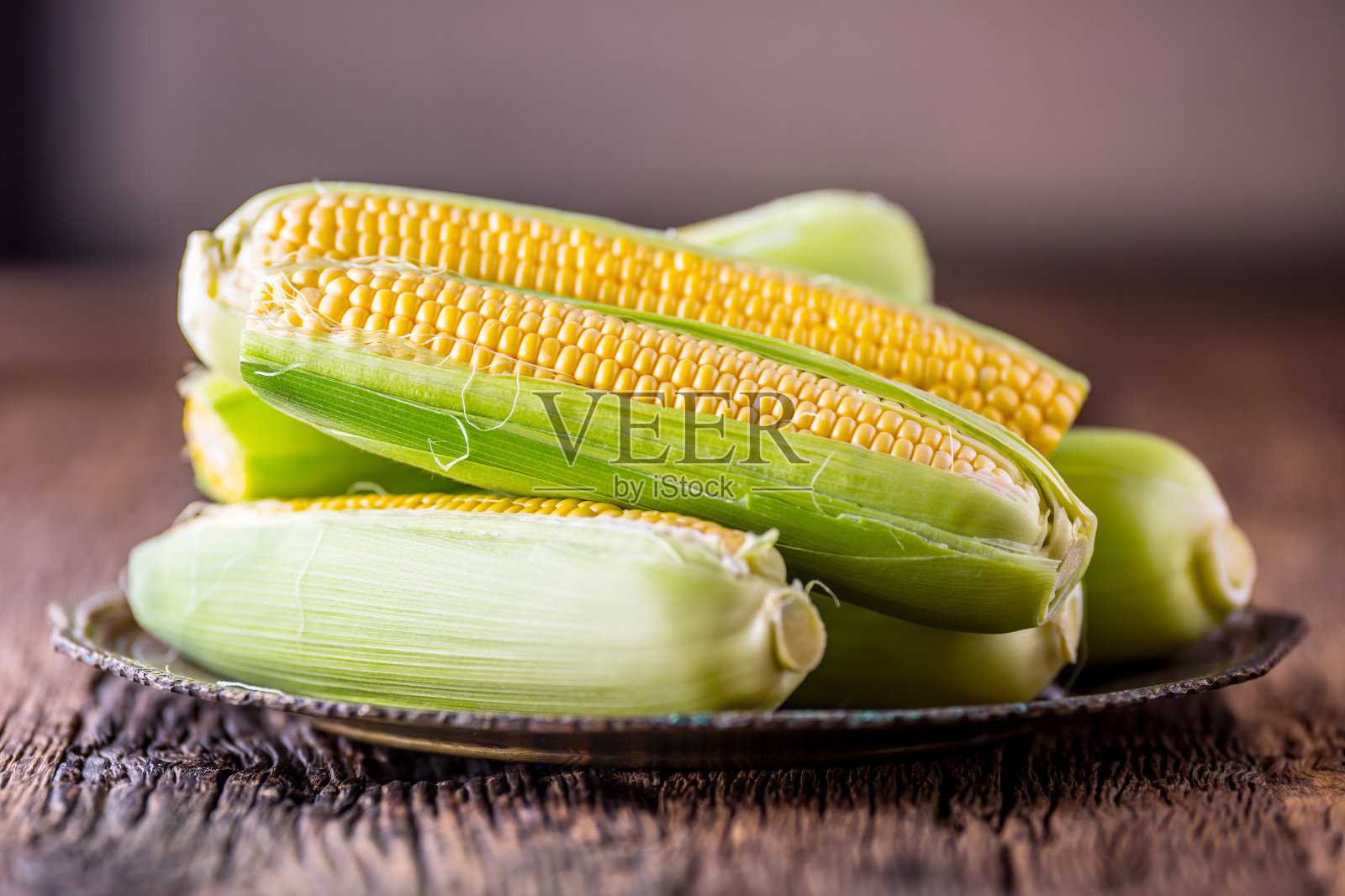 玉米。新鲜的玉米放在质朴的橡木桌子上照片摄影图片