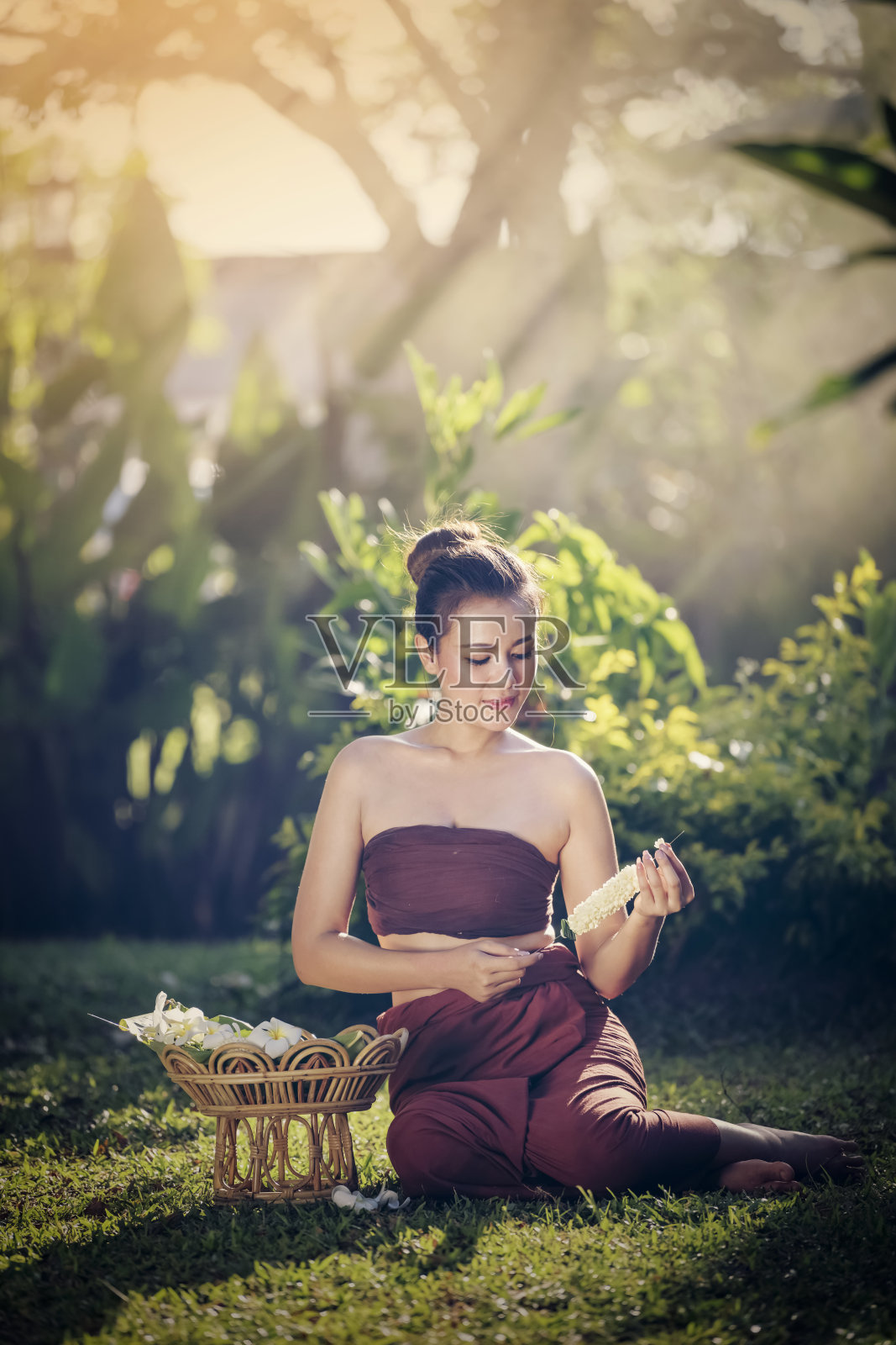 美丽的泰国女人。美丽的泰国女孩穿着传统服装。泰国传统，女子用鲜花做方向盘照片摄影图片