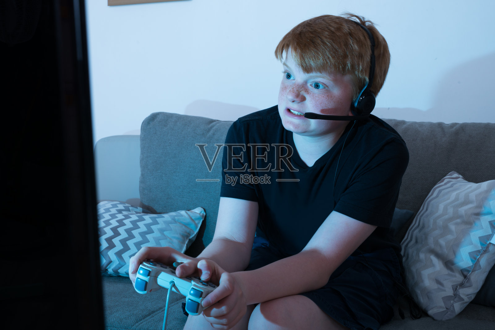 愤怒的男孩在玩电子游戏照片摄影图片
