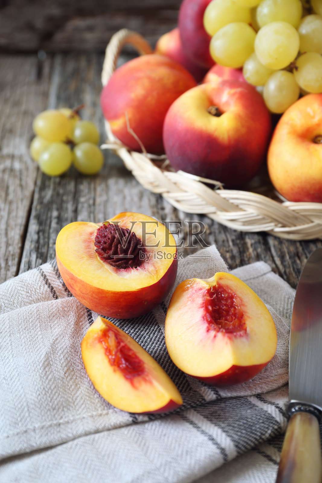 柳条篮子里的水果:青葡萄和桃子照片摄影图片
