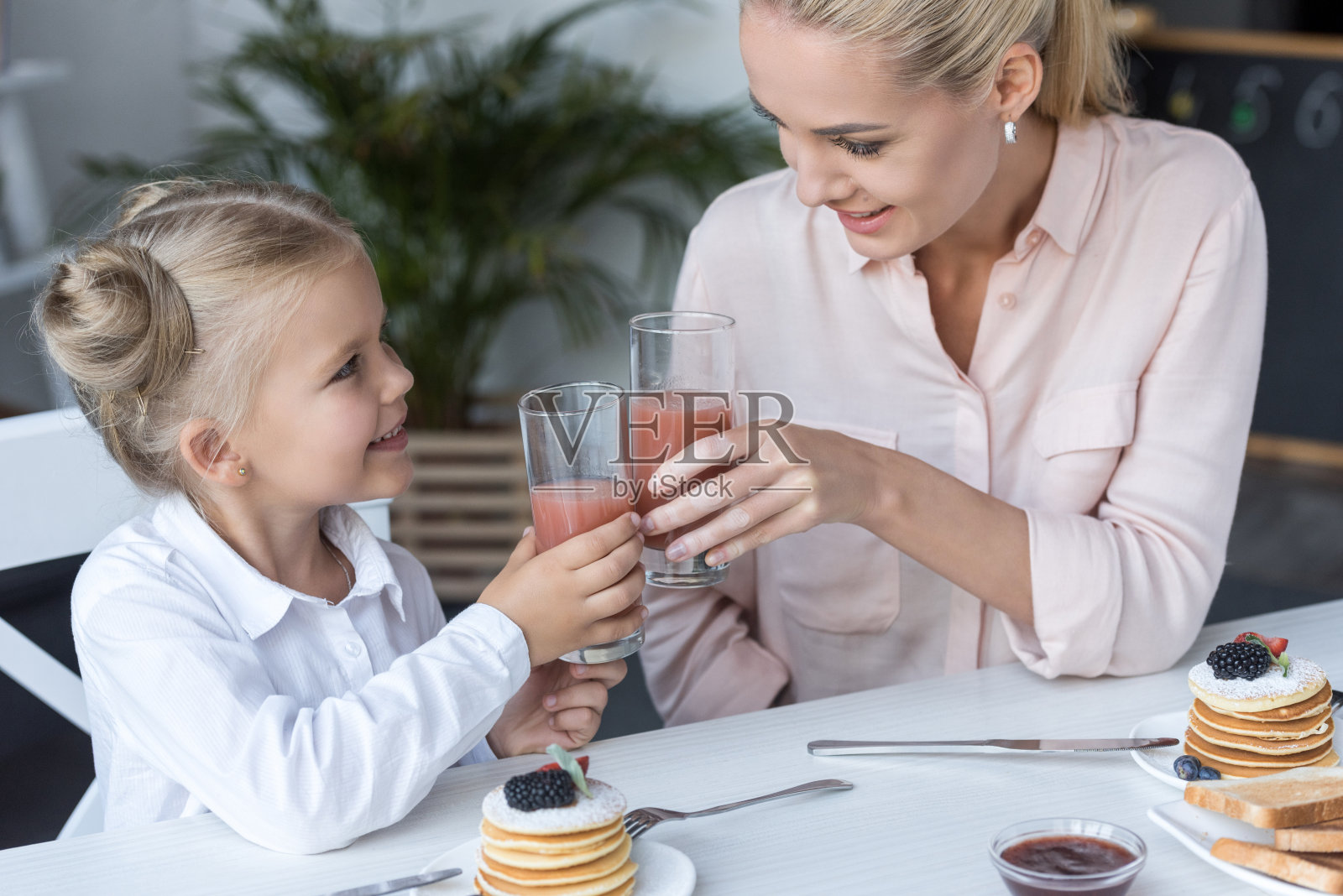 母亲和女儿喝果汁照片摄影图片