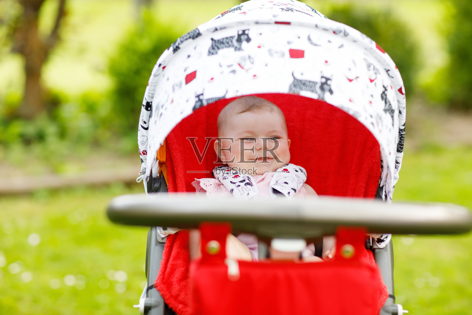 可爱的6个月的小女孩坐在婴儿车或婴儿车里等待妈妈照片摄影图片