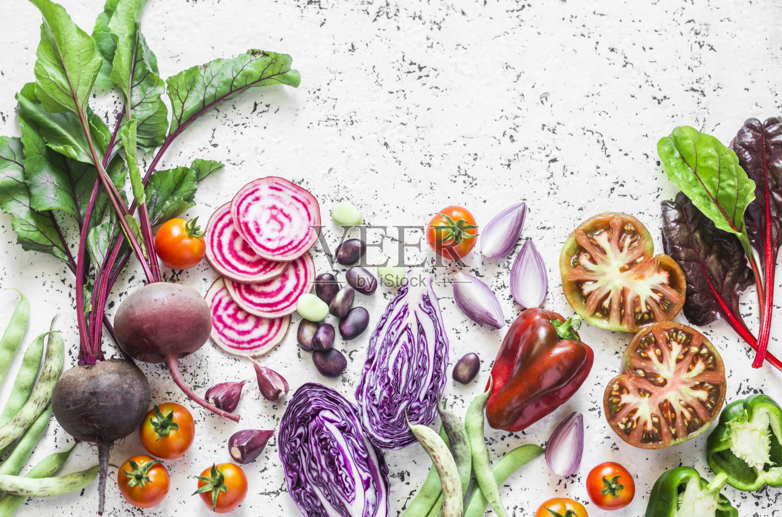 多种蔬菜的光背景。甜菜，红卷心菜，豆类，番茄，红洋葱，辣椒的食物背景。素食的概念照片摄影图片