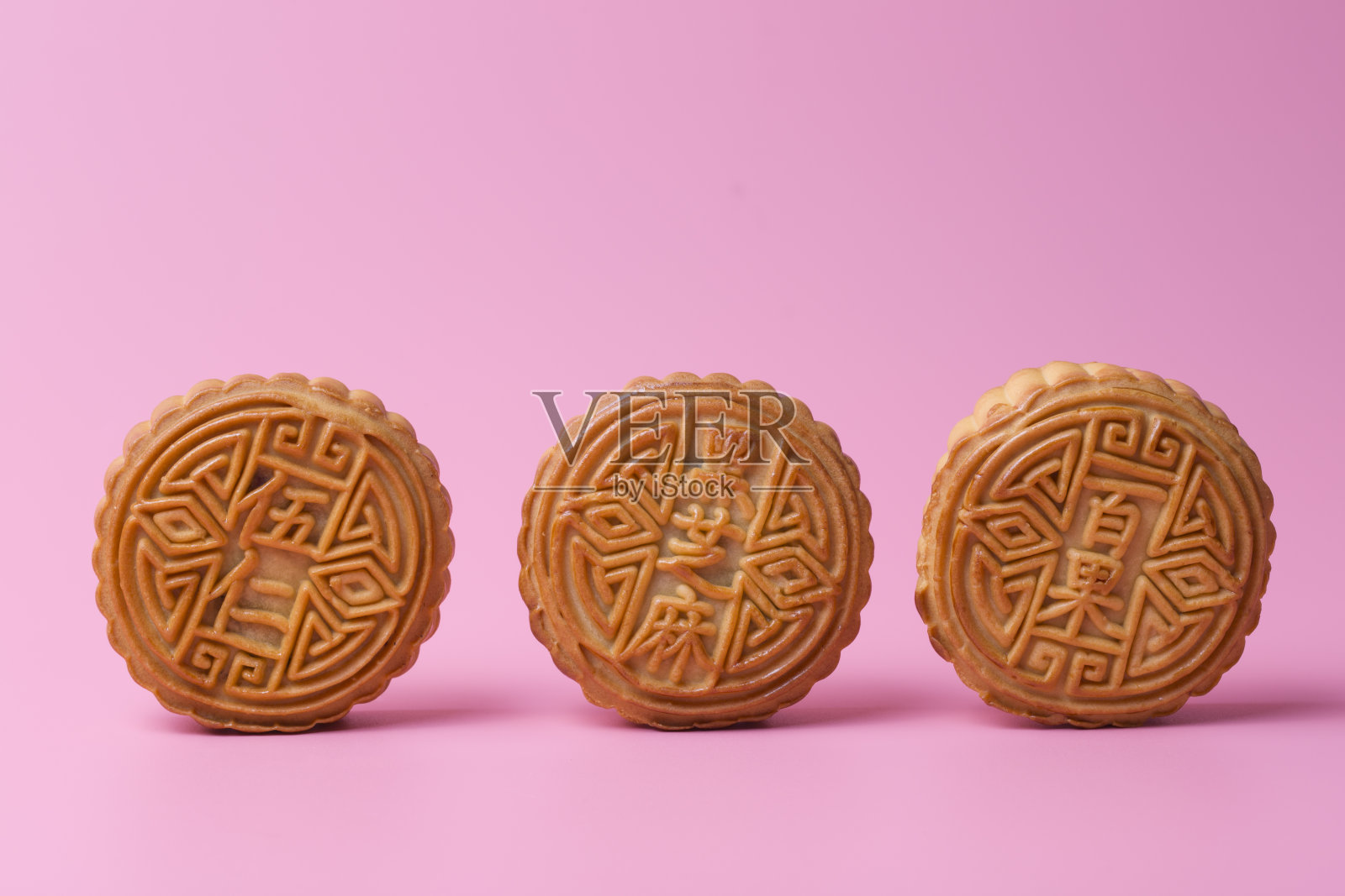 粉红色背景上的月饼。中国传统食物。照片摄影图片