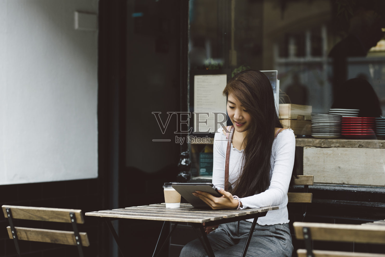 年轻女子在咖啡馆里使用平板电脑照片摄影图片