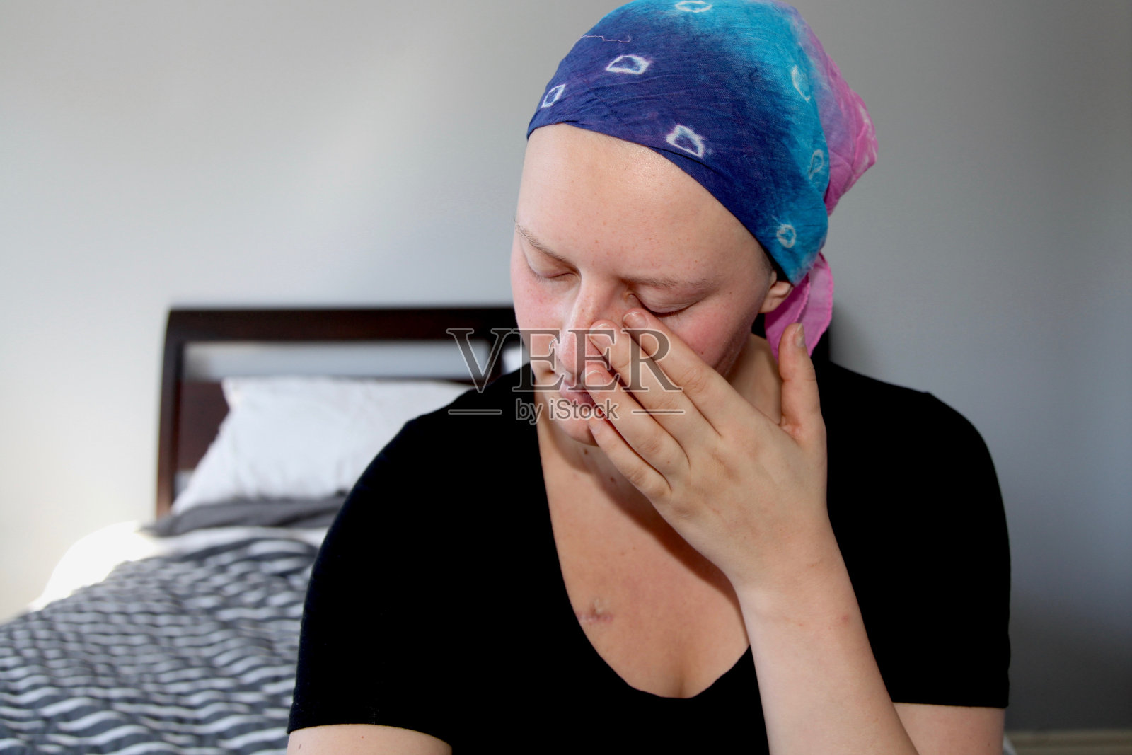 一名年轻的癌症患者擦眼泪的大头照照片摄影图片