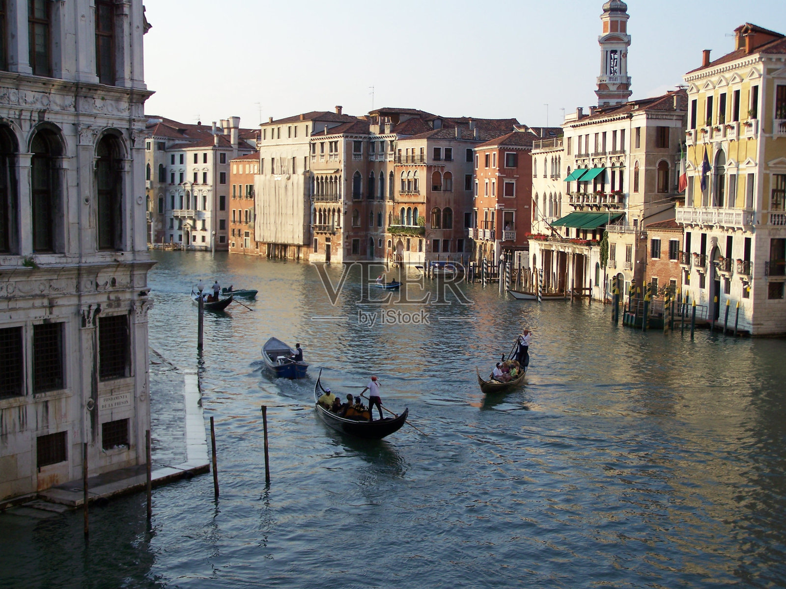 威尼斯运河的风景在一个阳光明媚的日子与贡多拉照片摄影图片