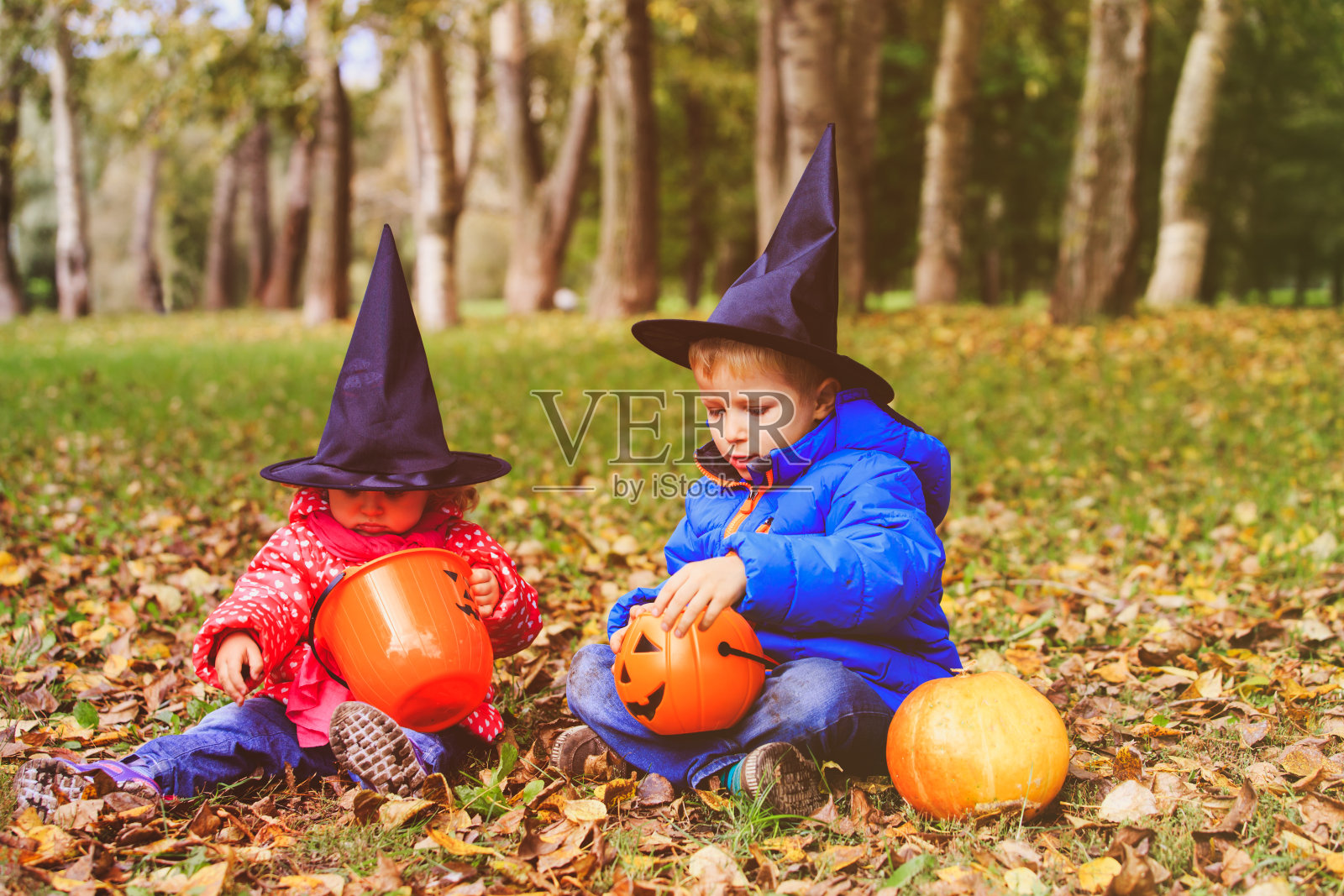 孩子们穿着万圣节服装在秋天玩，不给糖就捣蛋照片摄影图片