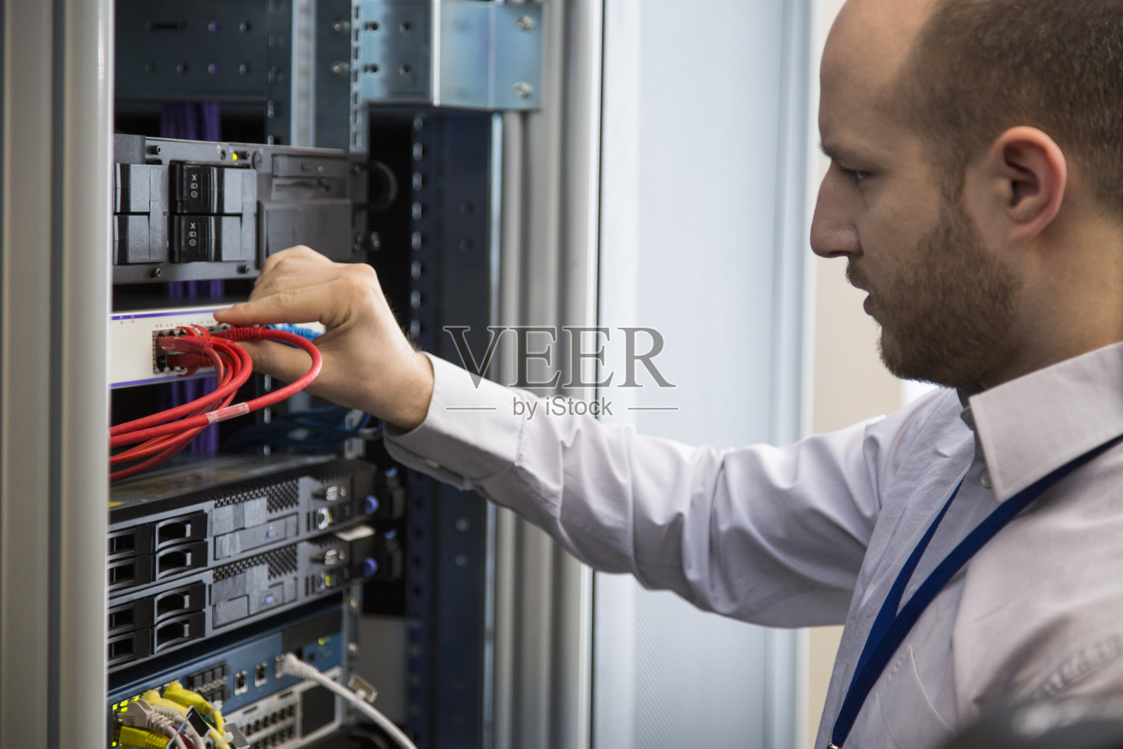 IT工程师在服务器机房连接线缆照片摄影图片