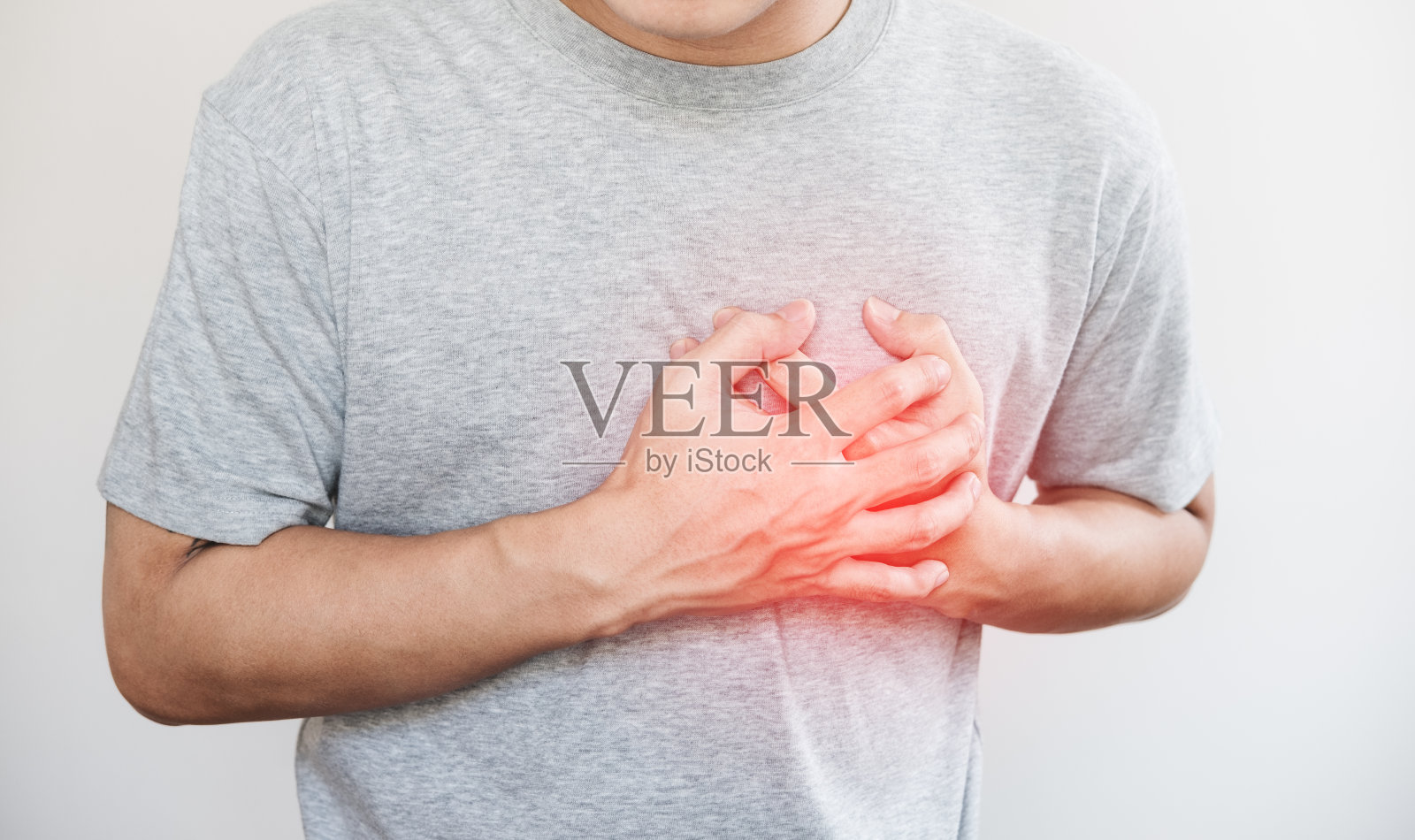 一个男人摸着自己的心，用红色突出心脏病发作的概念，用白色作背景照片摄影图片