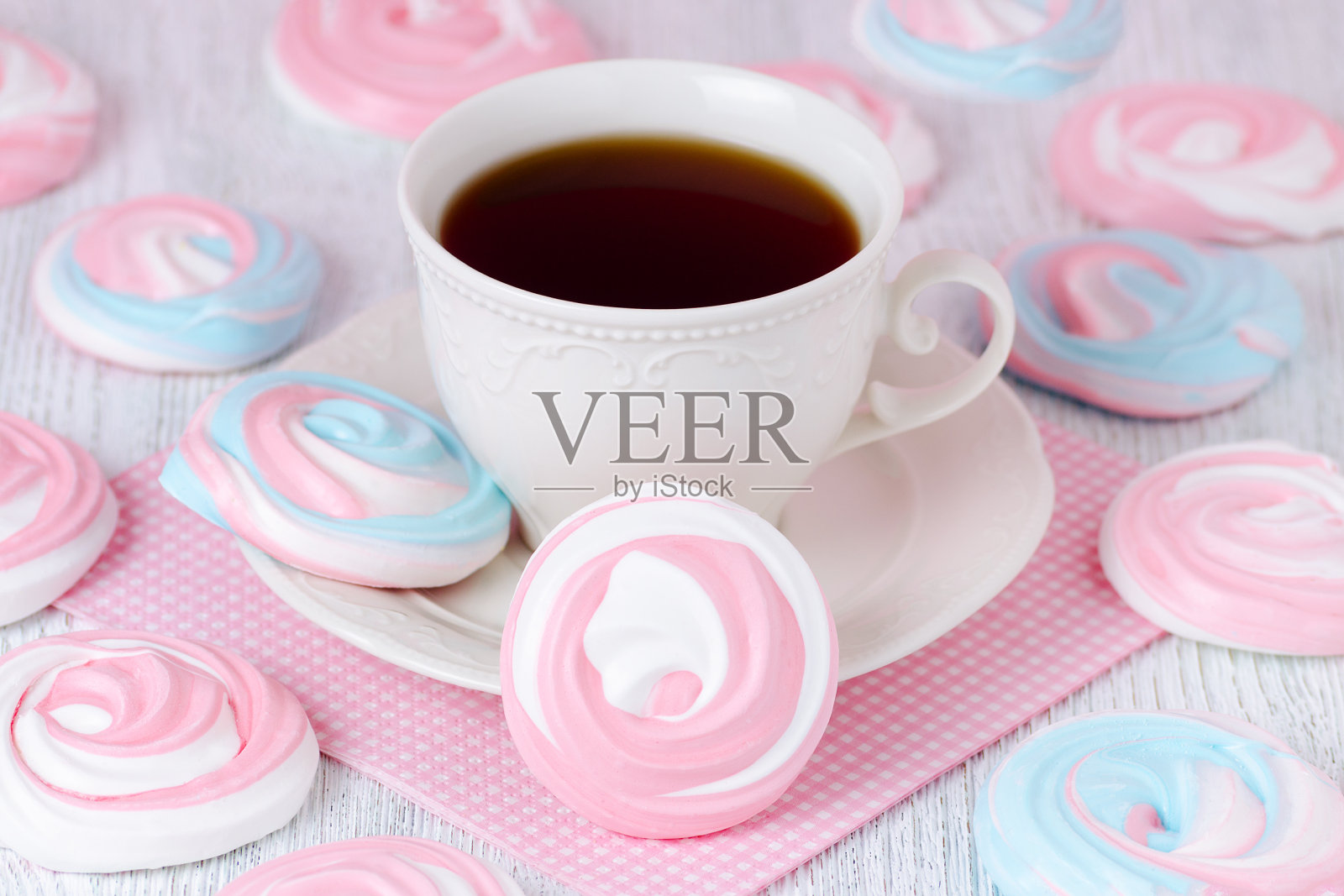 柔和的蛋白糖霜配一杯咖啡和一条粉色餐巾照片摄影图片