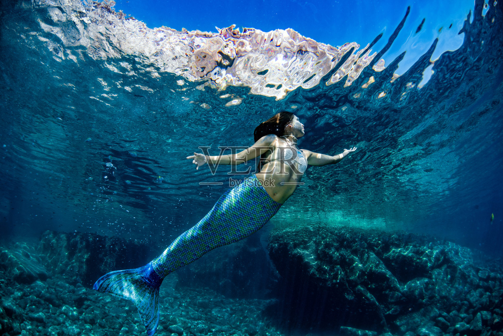 美人鱼在深蓝色的海里游泳照片摄影图片
