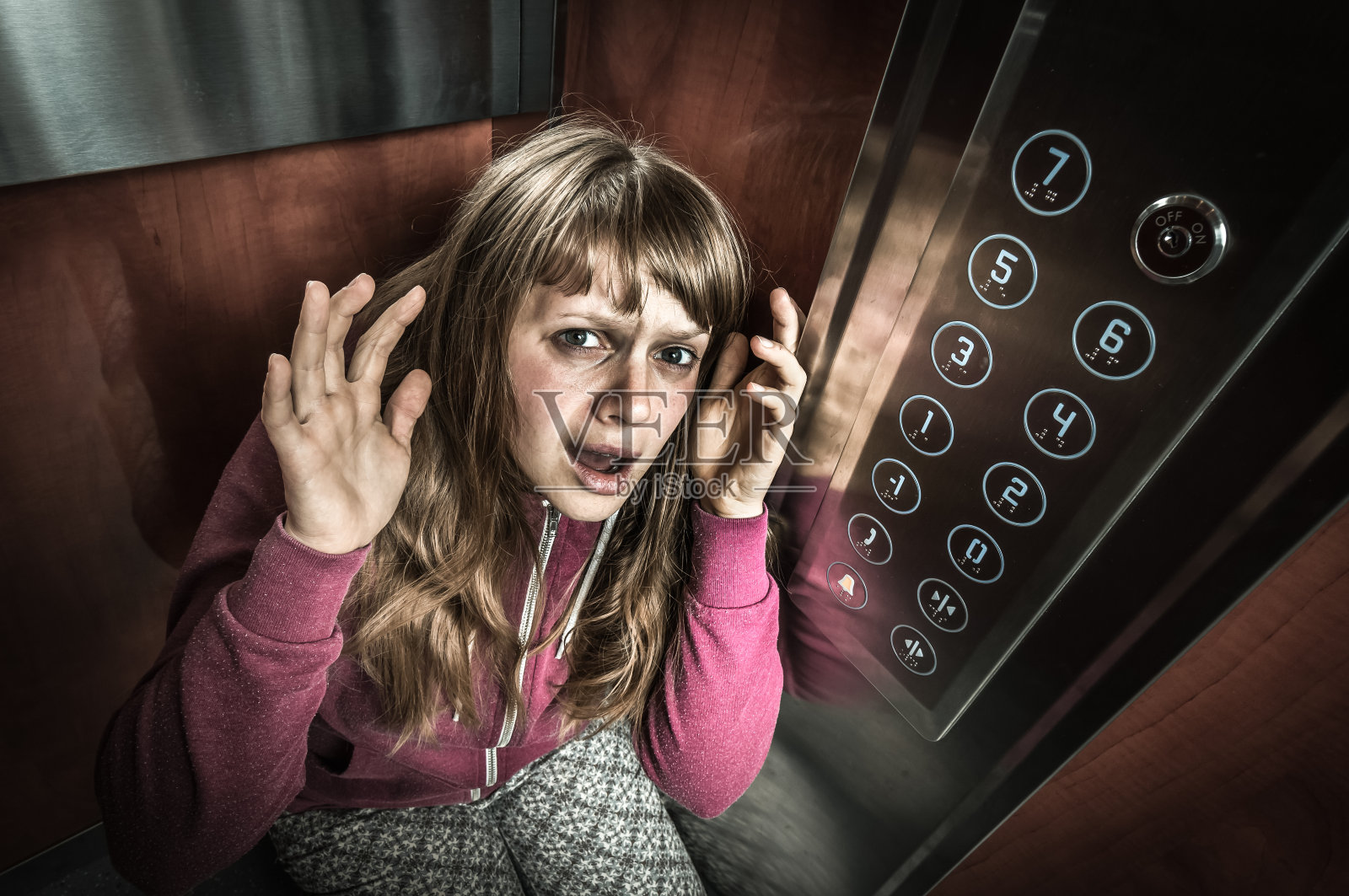 在移动的电梯里有幽闭恐怖症的震惊女人照片摄影图片