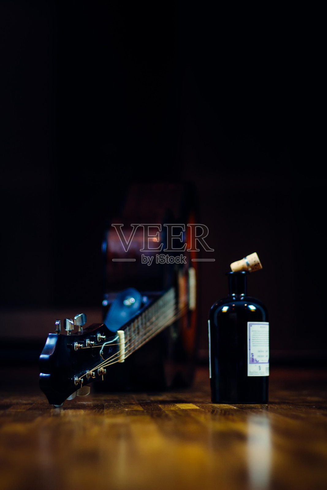 酒瓶和吉他是酗酒、摇滚和放荡生活方式的概念照片摄影图片