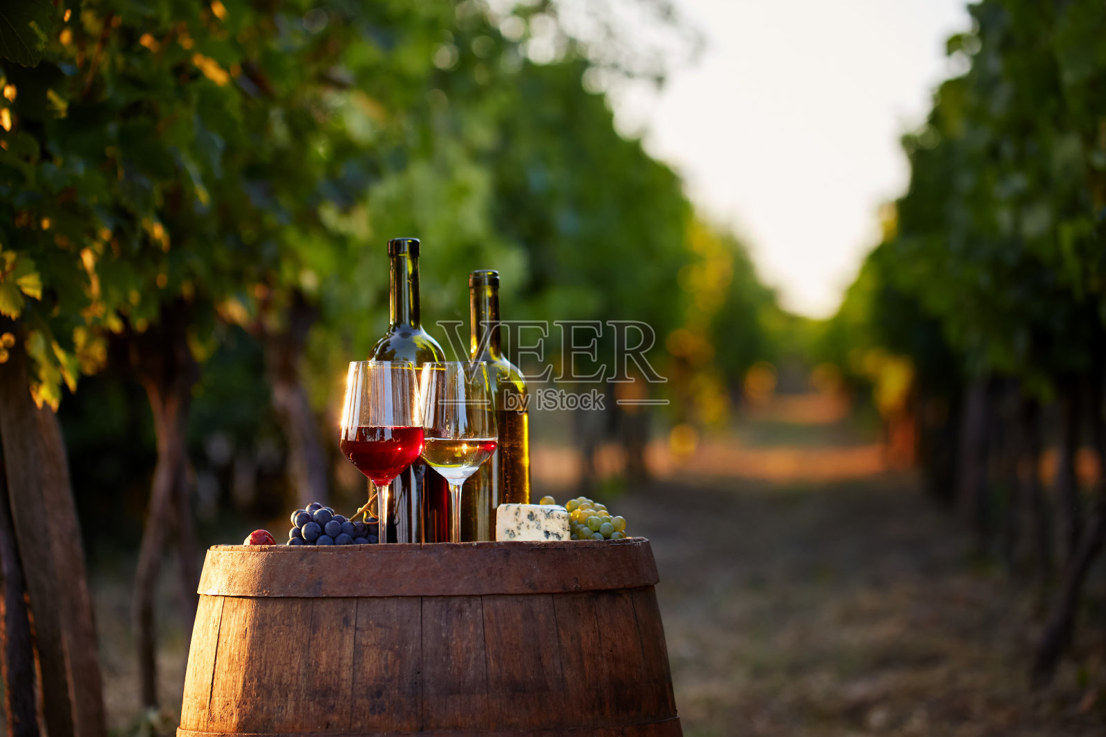日落时分喝两杯白葡萄酒和红酒。照片摄影图片