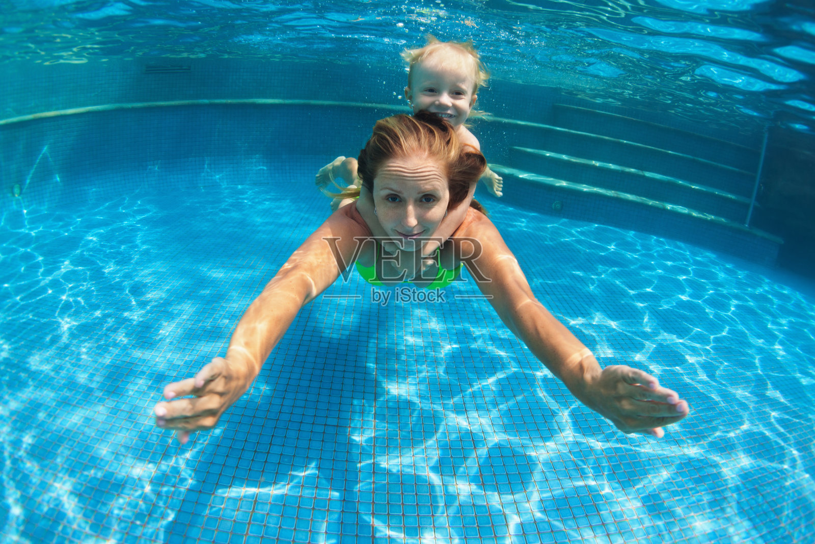 孩子和妈妈在游泳池里潜水照片摄影图片